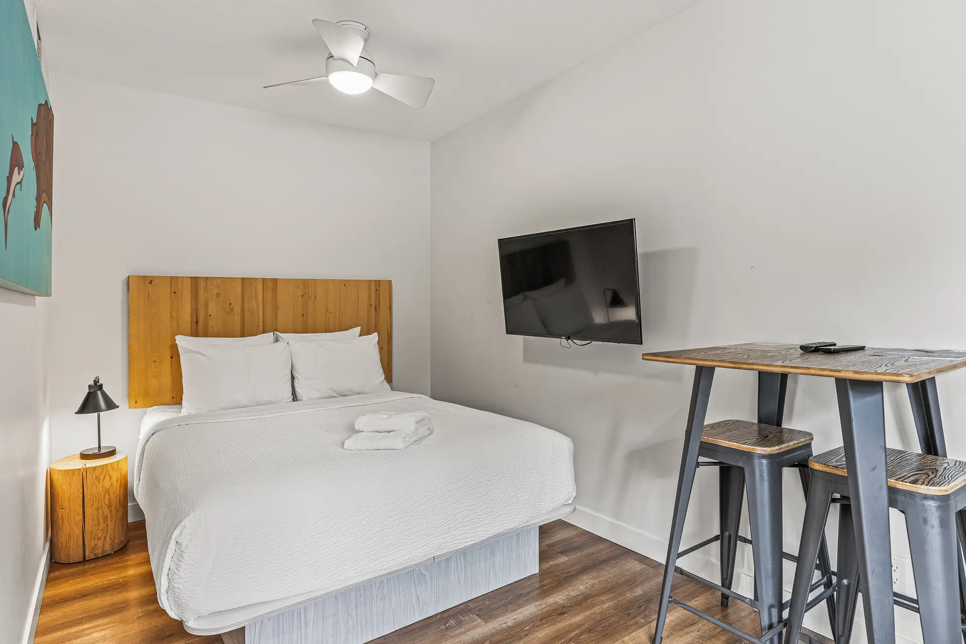 Basecamp Resorts Canmore micro studio with bed, TV, and high-top table