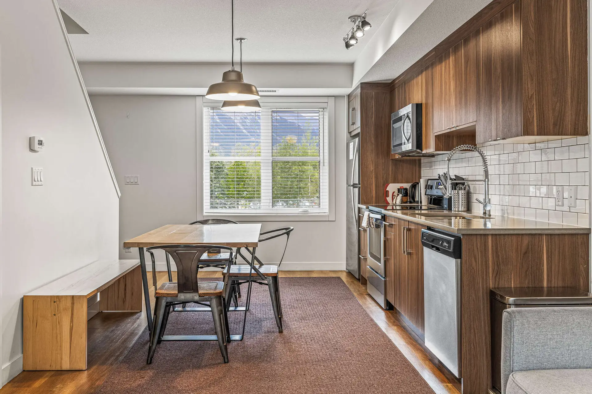 Modern kitchen and dining area in a Basecamp Resorts Canmore two-bedroom suite.