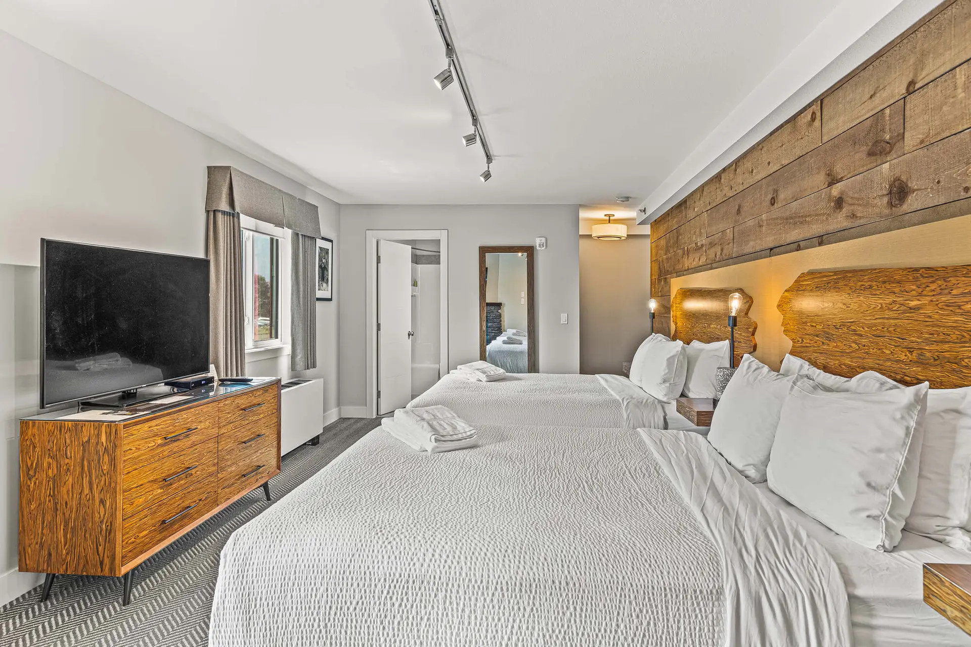 Deluxe double queen room at Basecamp Lodge Canmore with rustic wood accents.