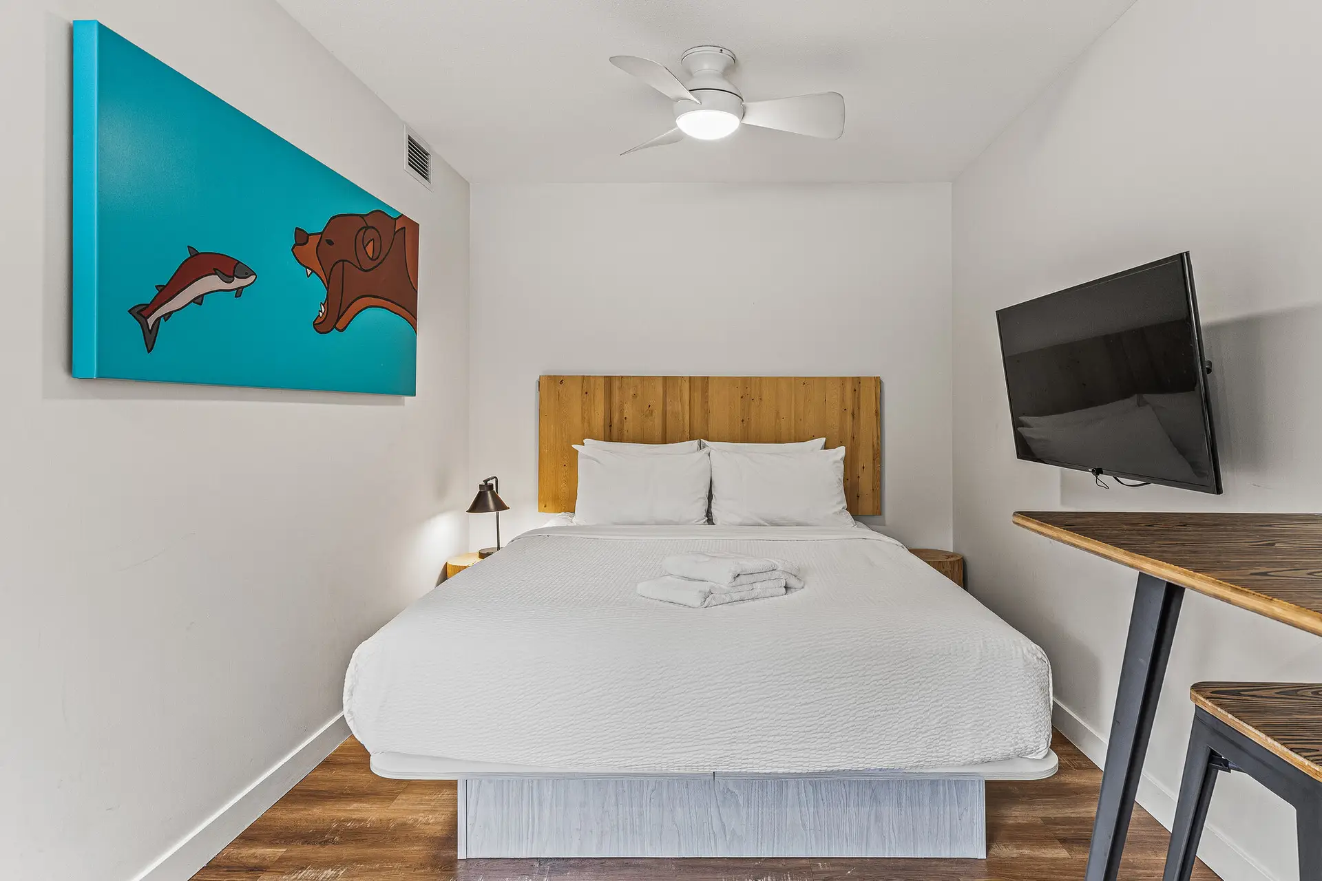 Basecamp Resorts Canmore micro studio with queen bed, TV, and bear art.