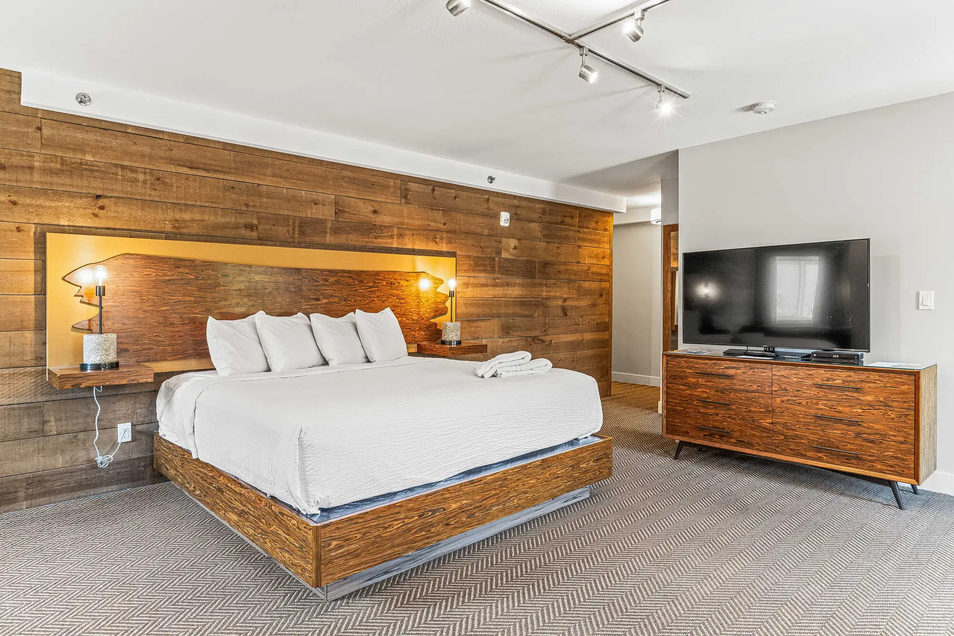 King suite at Basecamp Lodge Canmore with wood accent wall.