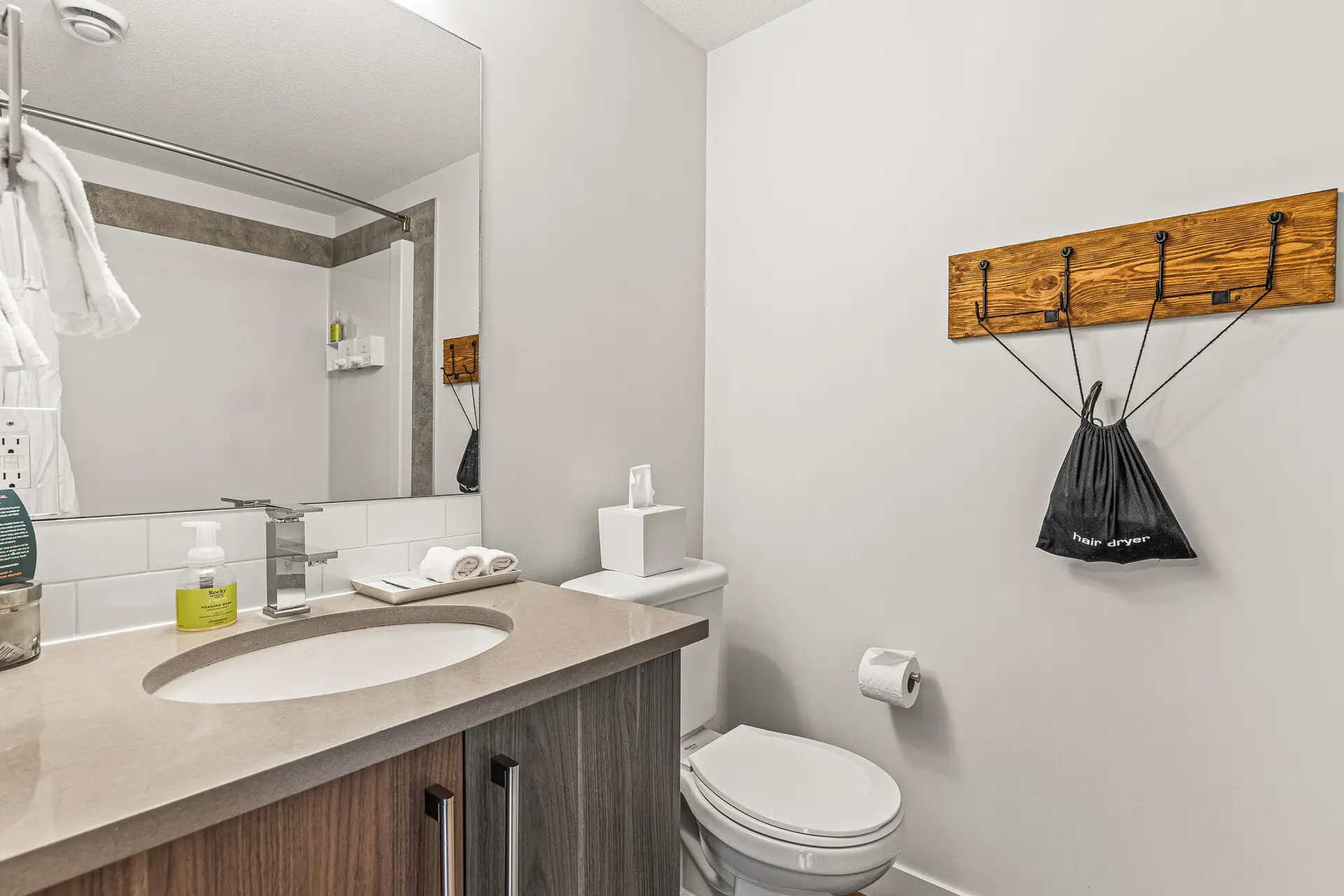 Modern bathroom with beige countertop, sink, toilet, and towel rack