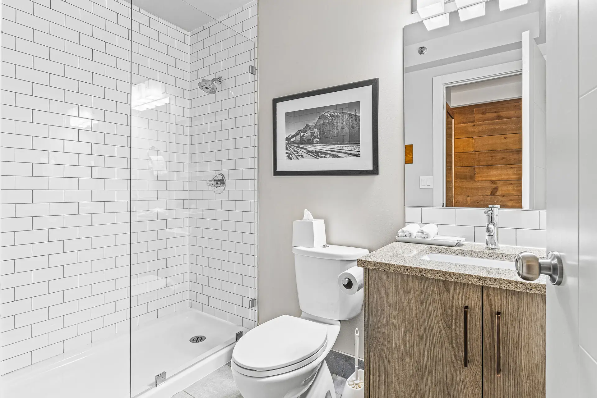 Basecamp Lodge Canmore King Suite bathroom: tiled shower, toilet, vanity with granite countertop.