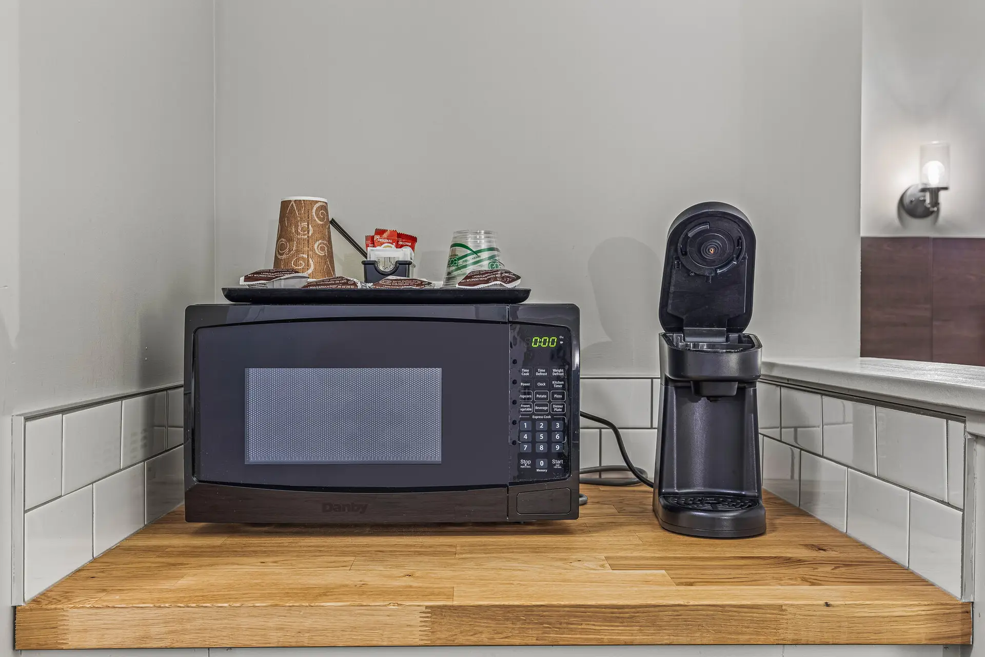 Deluxe Double Queen room at Basecamp Northwinds Canmore features microwave, coffee maker, and coffee supplies.