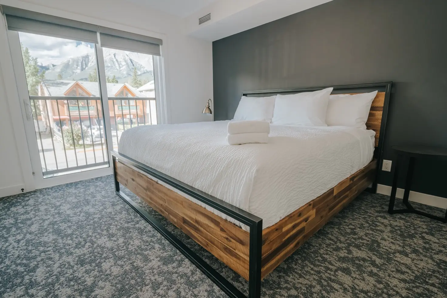Modern bedroom at Basecamp Suites Canmore with king bed and mountain view.