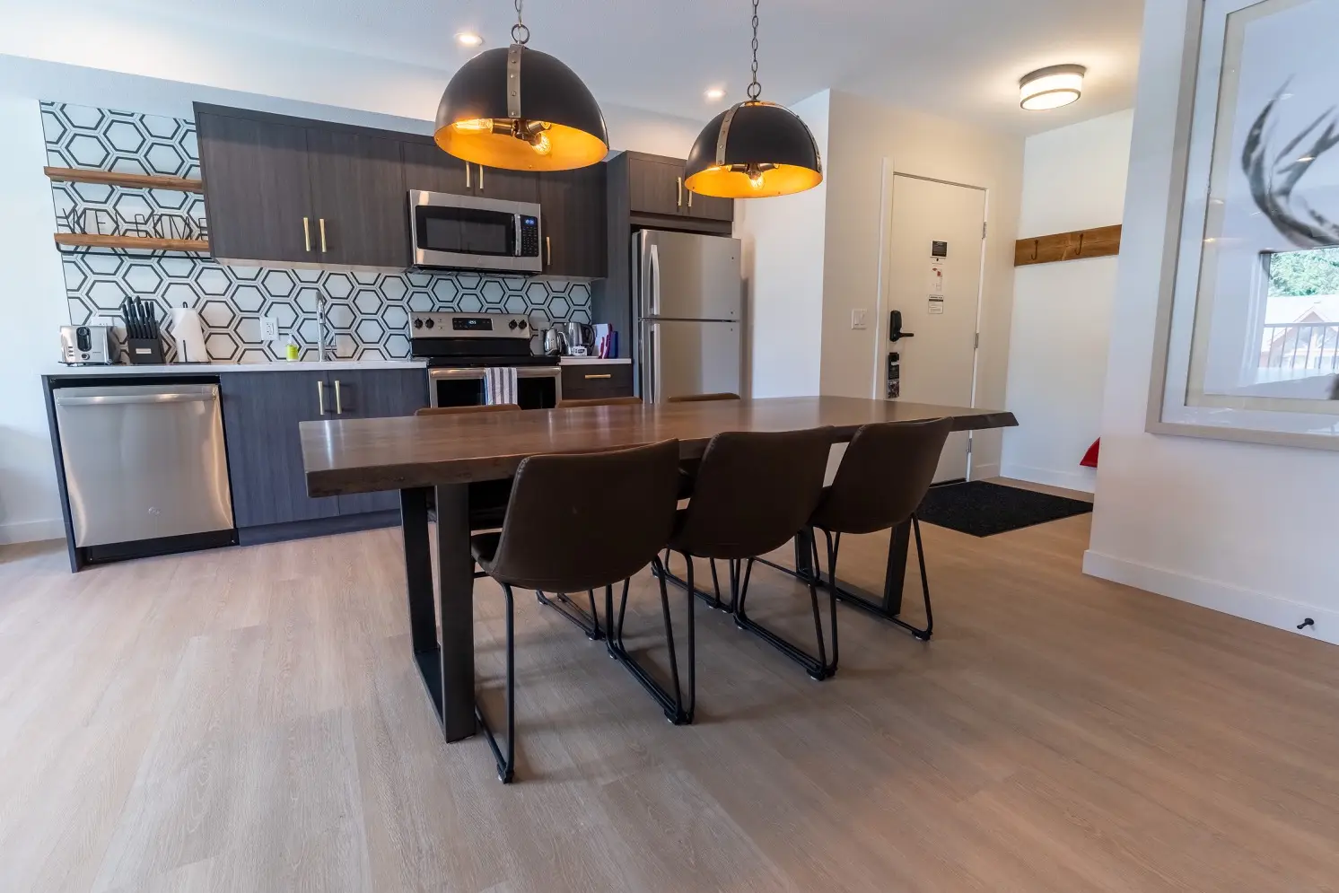 Modern kitchen and dining area in a Basecamp Suites Canmore two-bedroom suite.