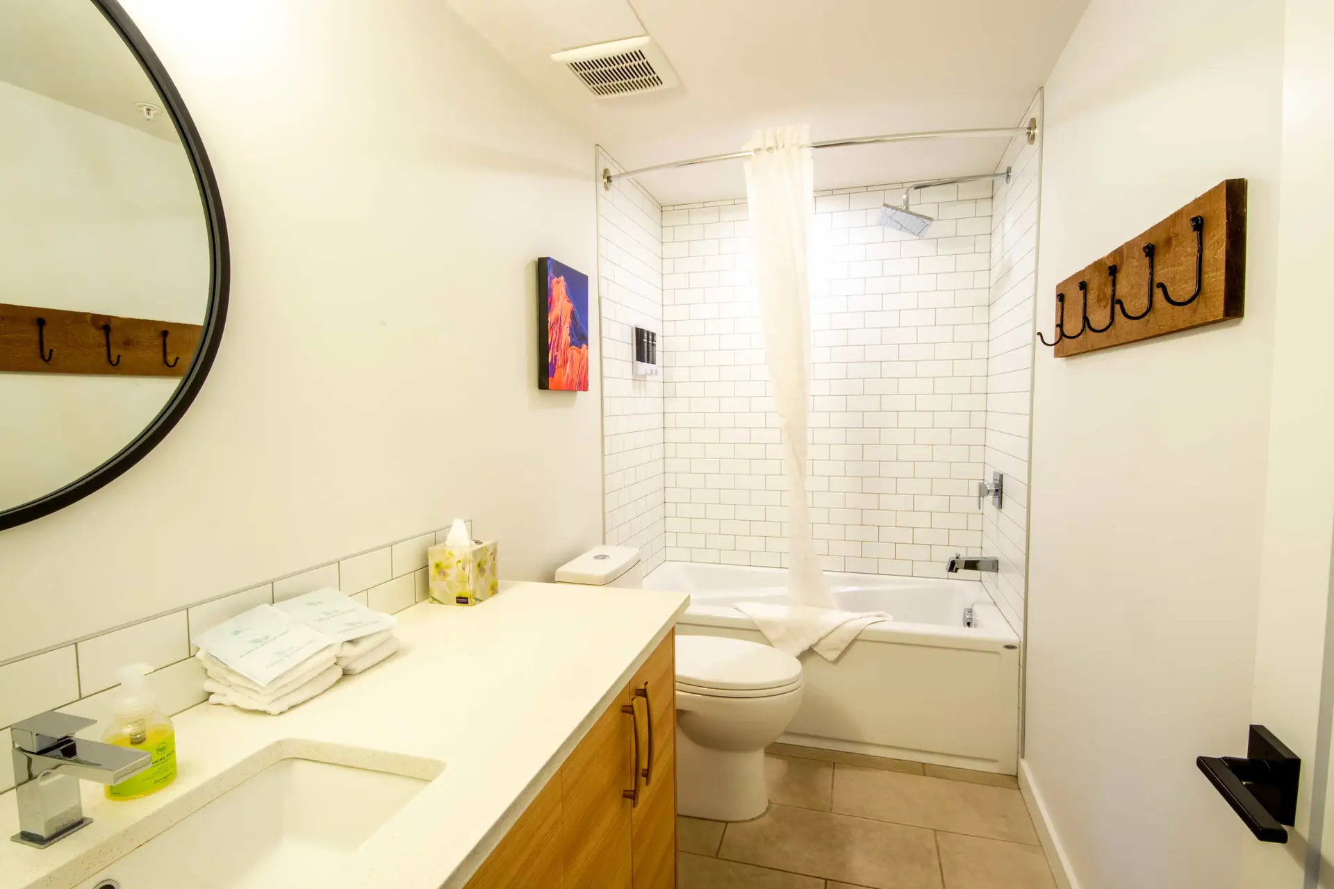 Modern bathroom with white subway tile, bathtub, toilet, and vanity at Basecamp Resorts Revelstoke.