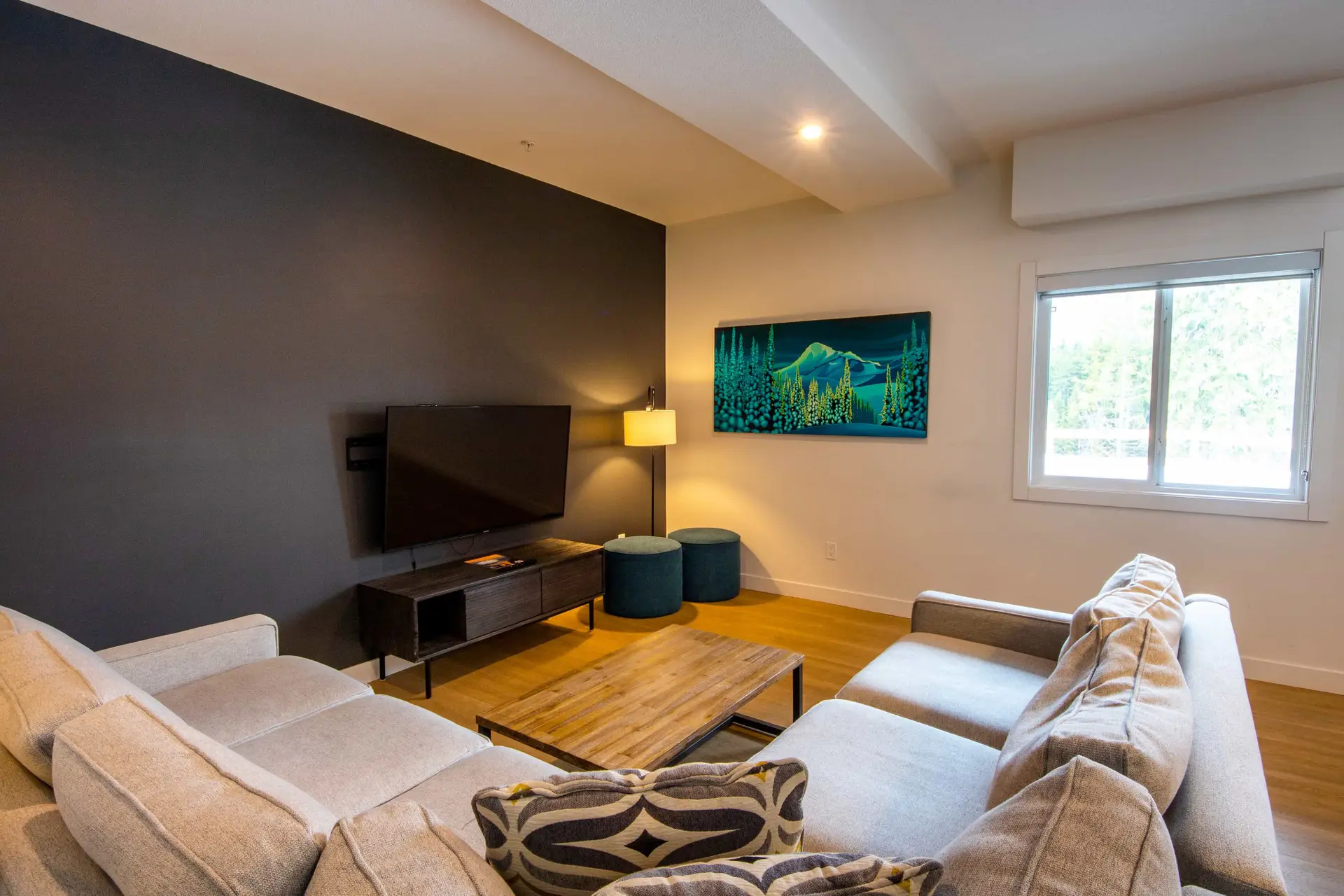 Living room at Basecamp Resorts Revelstoke with sectional sofa and mountain art