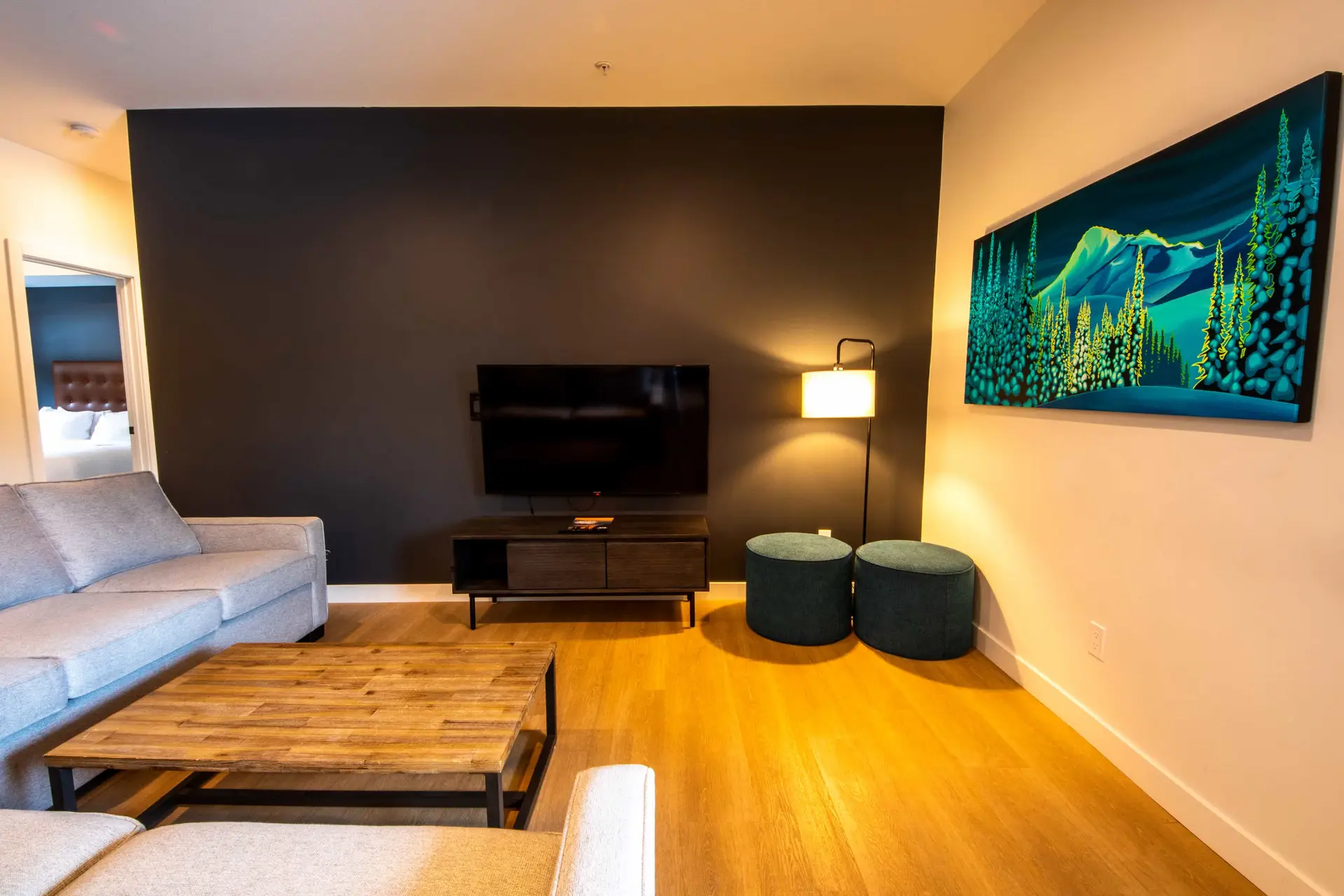 Living room of Basecamp Resorts Revelstoke Three Bedroom with bunk suite, featuring a sofa, coffee table, and artwork.