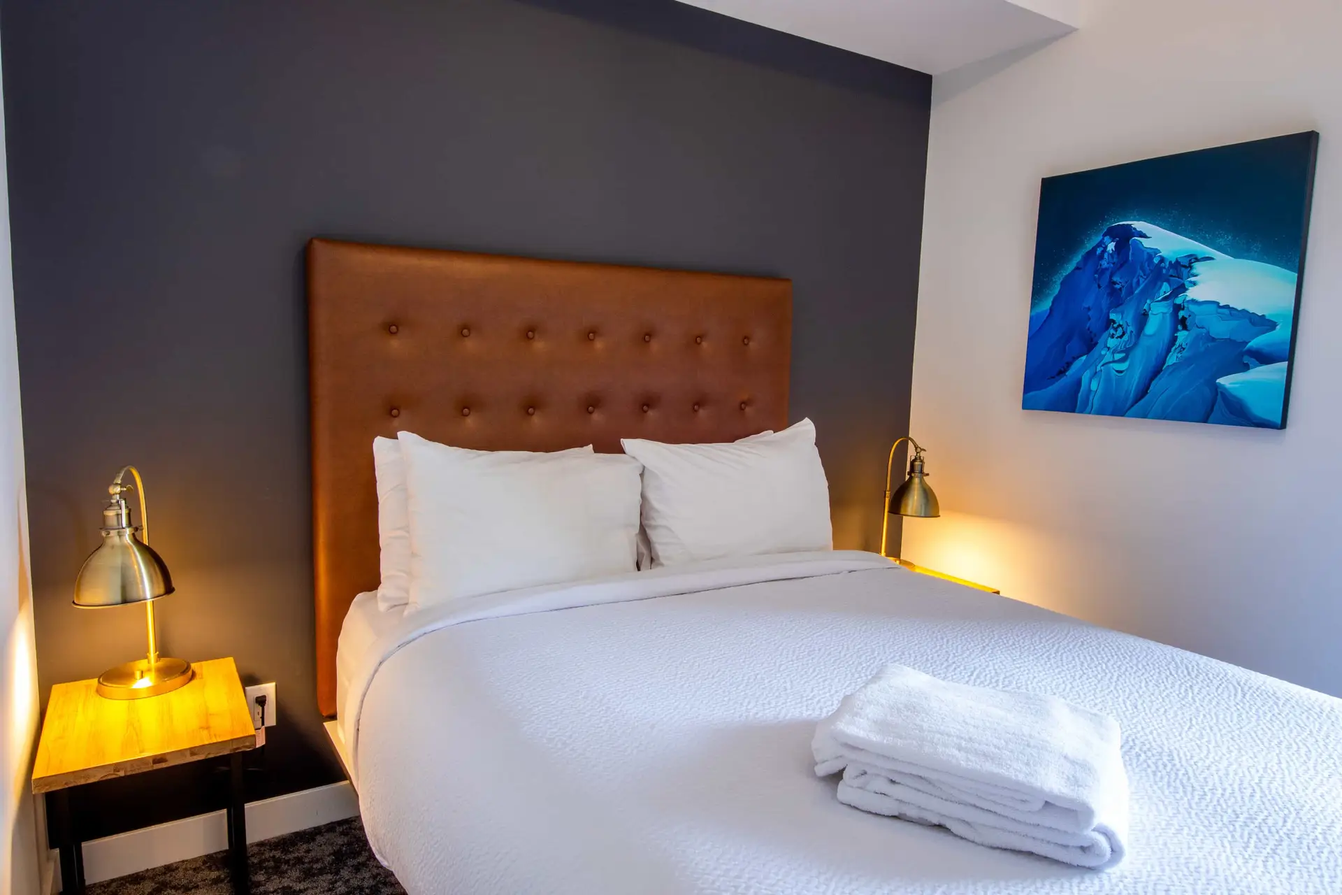 Revelstoke bunk suite bedroom with mountain art and cozy bedding.