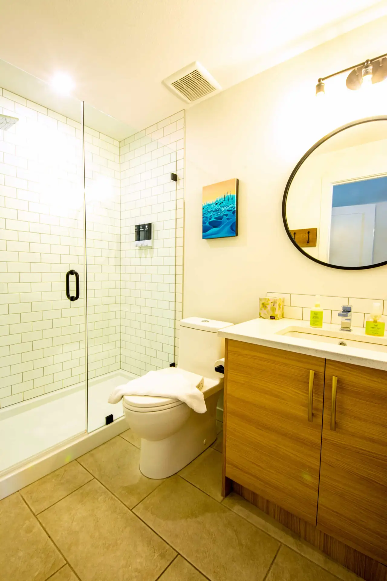 Modern bathroom with walk-in shower, white subway tile, and wood vanity