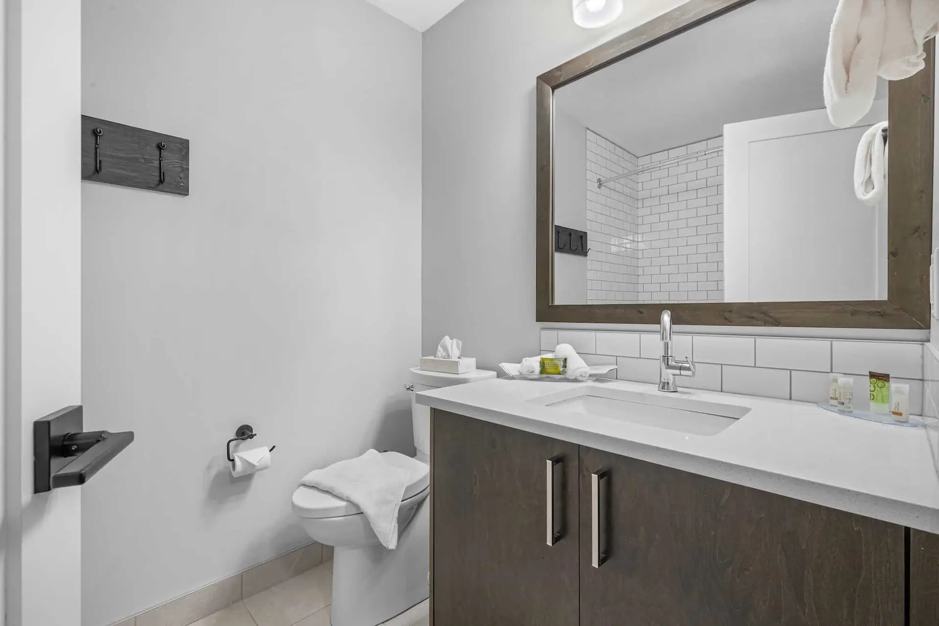 Deluxe King room bathroom at Basecamp Northwinds Canmore with vanity, toilet, and shower.