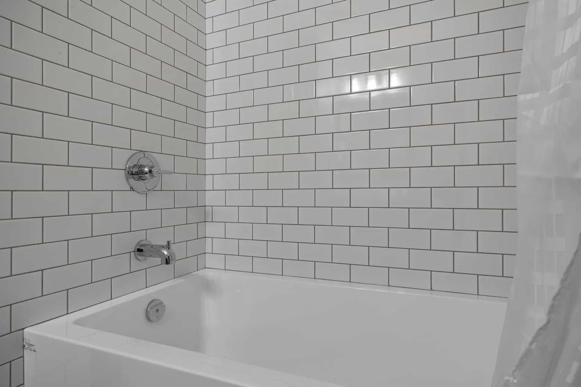 Deluxe King room bathroom at Basecamp Northwinds Canmore with white subway tile tub and shower.