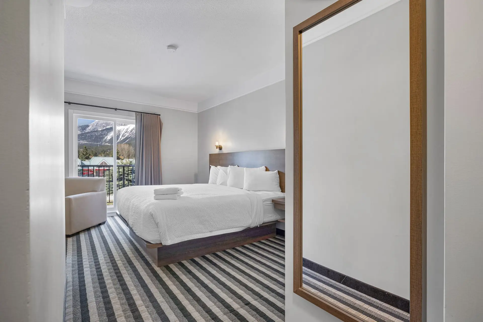 King bed in Basecamp Northwinds Canmore room with mountain view balcony