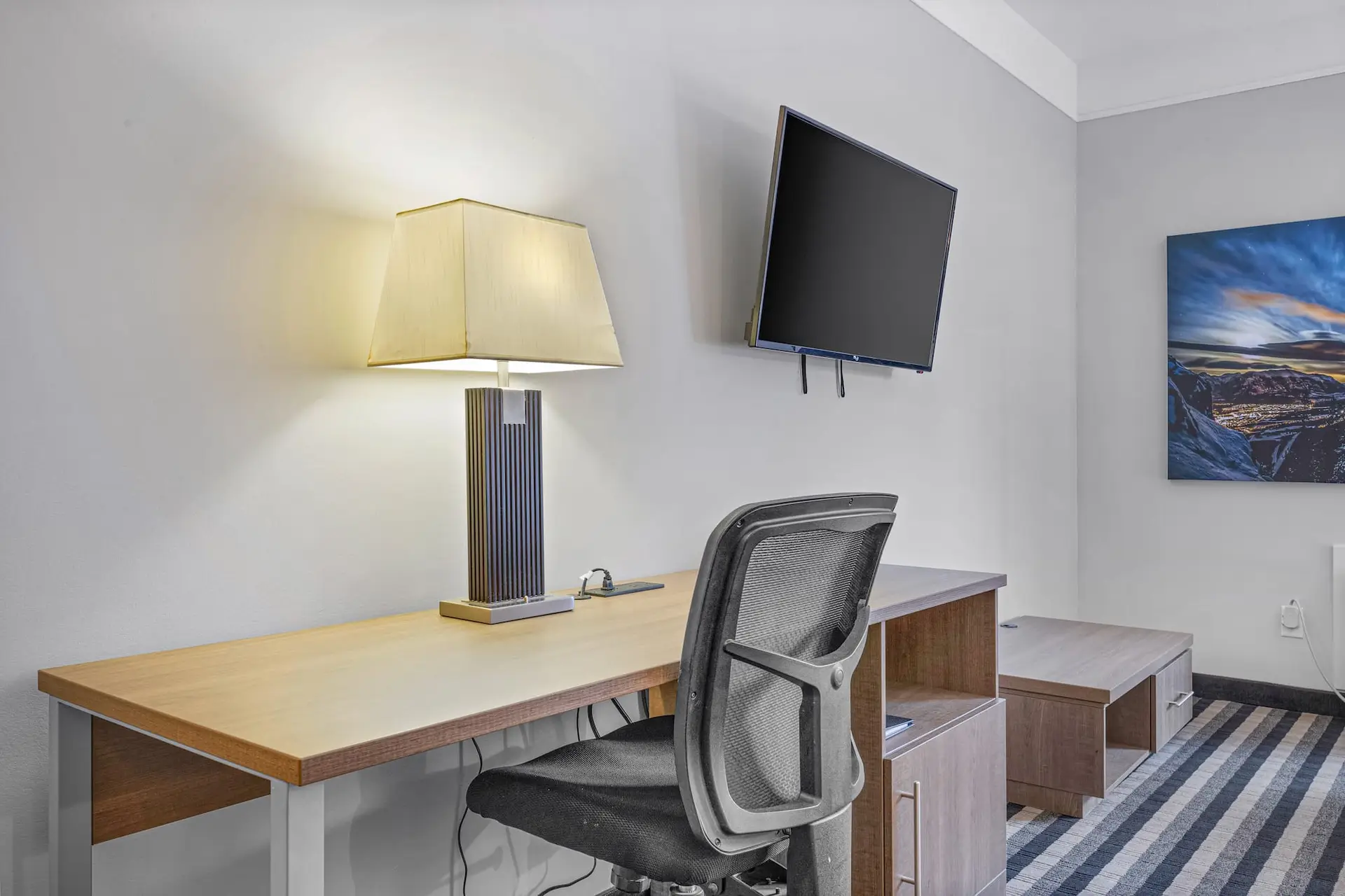 Desk, chair, and TV in a hotel room at Basecamp Northwinds Canmore.