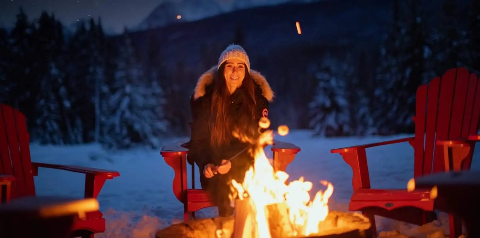Woman roasting marshmallows by fire pit at Baker Creek by Basecamp