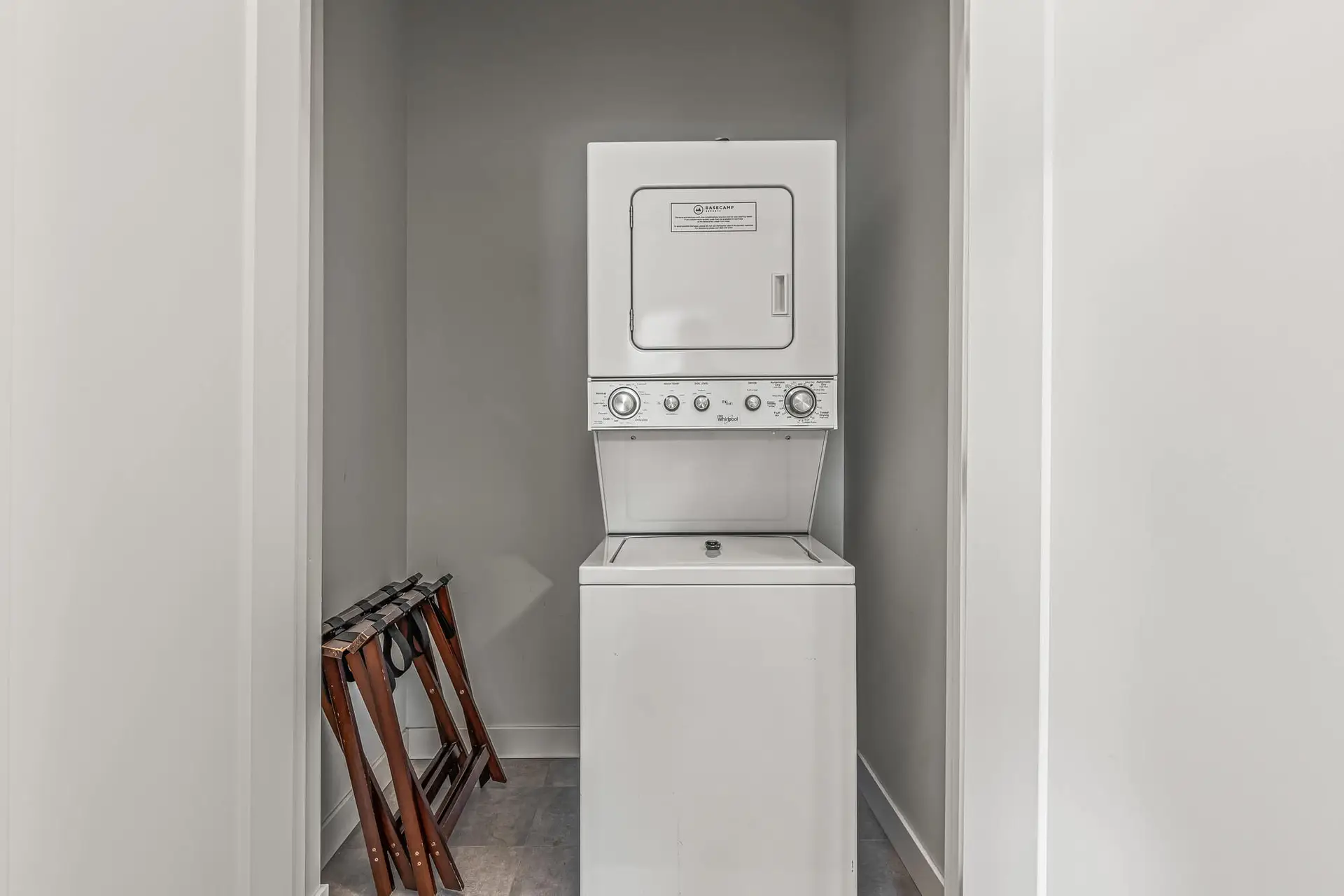 Stacked Whirlpool washer and dryer in a laundry closet at Basecamp Resorts Canmore.