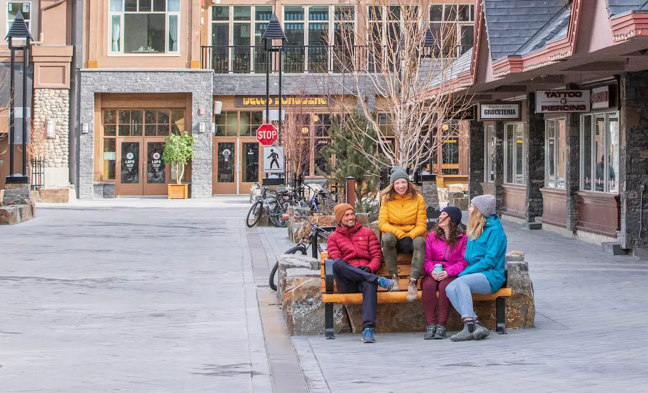 Group of friends relaxing on a bench outside Banff Suites