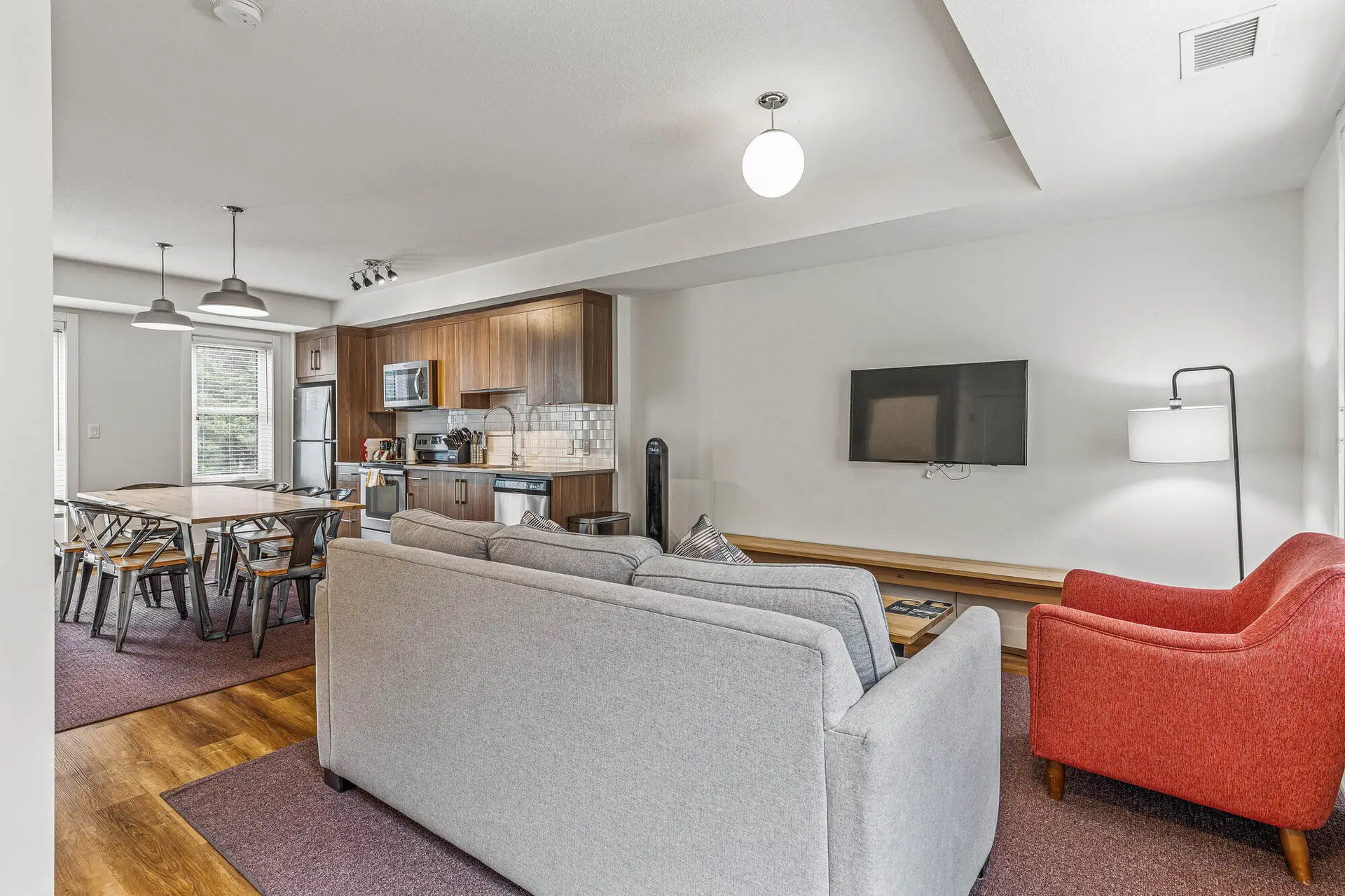 Modern living area and kitchen in a Basecamp Resorts Canmore five-bedroom suite.