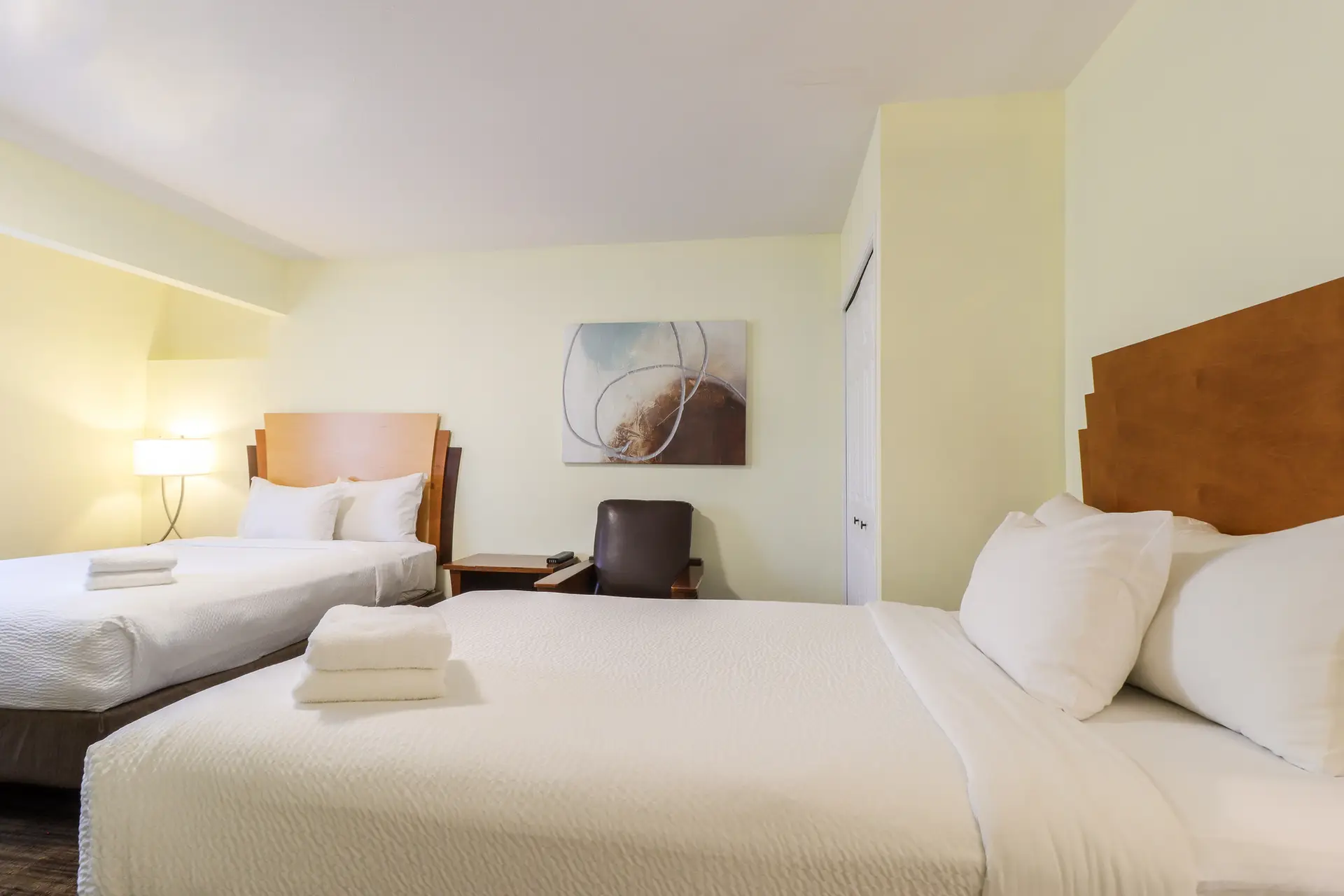 Basecamp Northwinds Revelstoke apartment bedroom with two queen beds and artwork.
