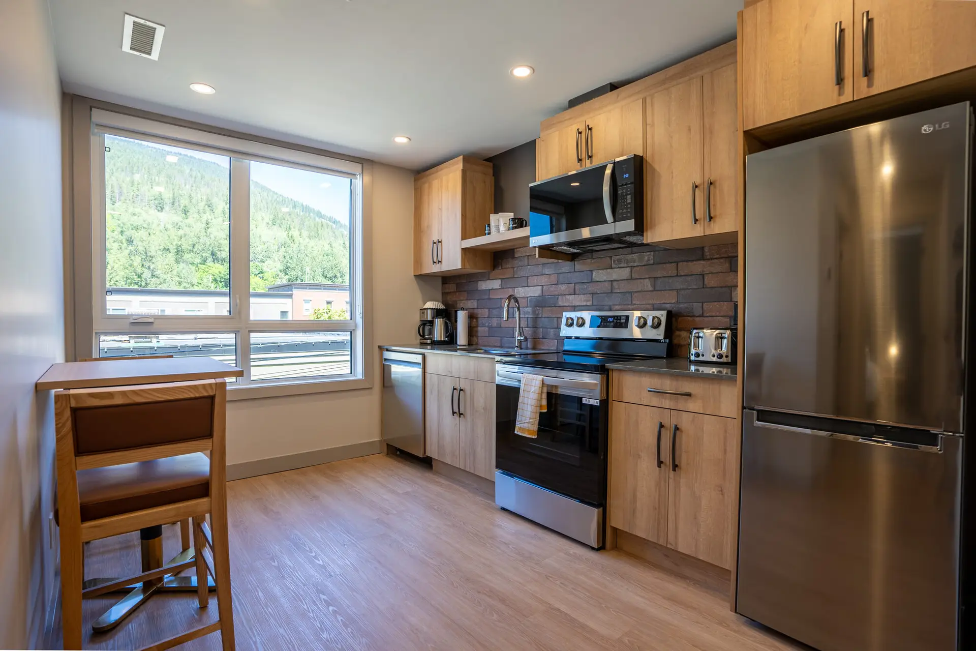 Modern kitchen in a Revelstoke six-bedroom suite with stainless steel appliances and wood cabinetry.