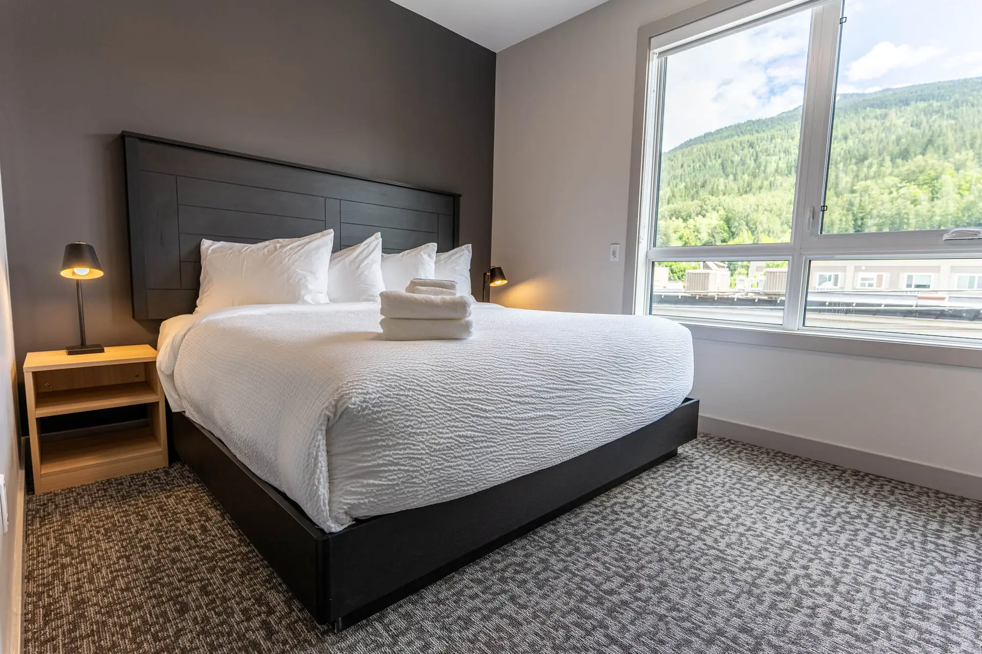 Modern hotel suite bedroom in Revelstoke with king bed and mountain view