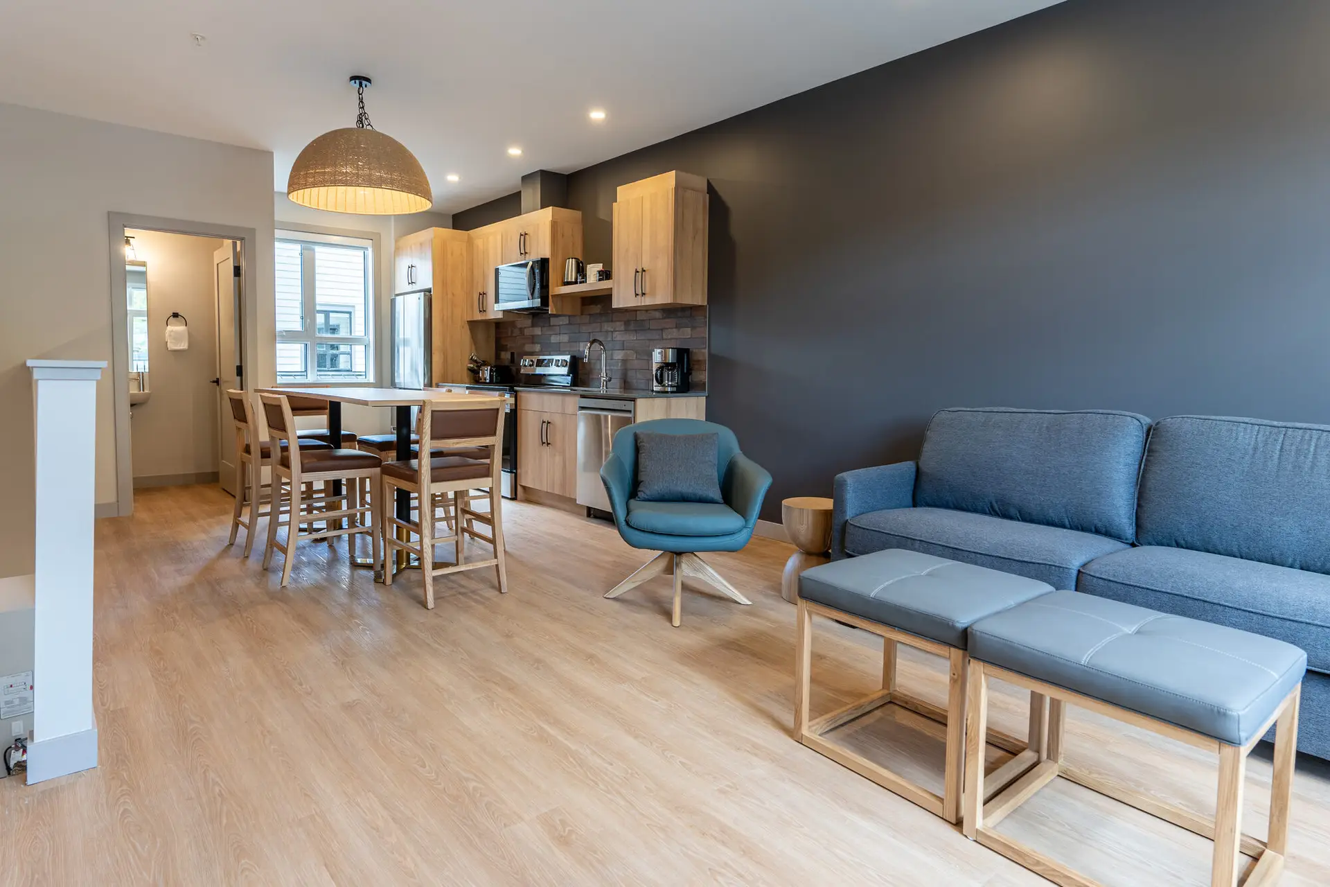 Basecamp Suites Revelstoke: Modern four-bedroom suite with open-plan living, dining, and kitchen area.