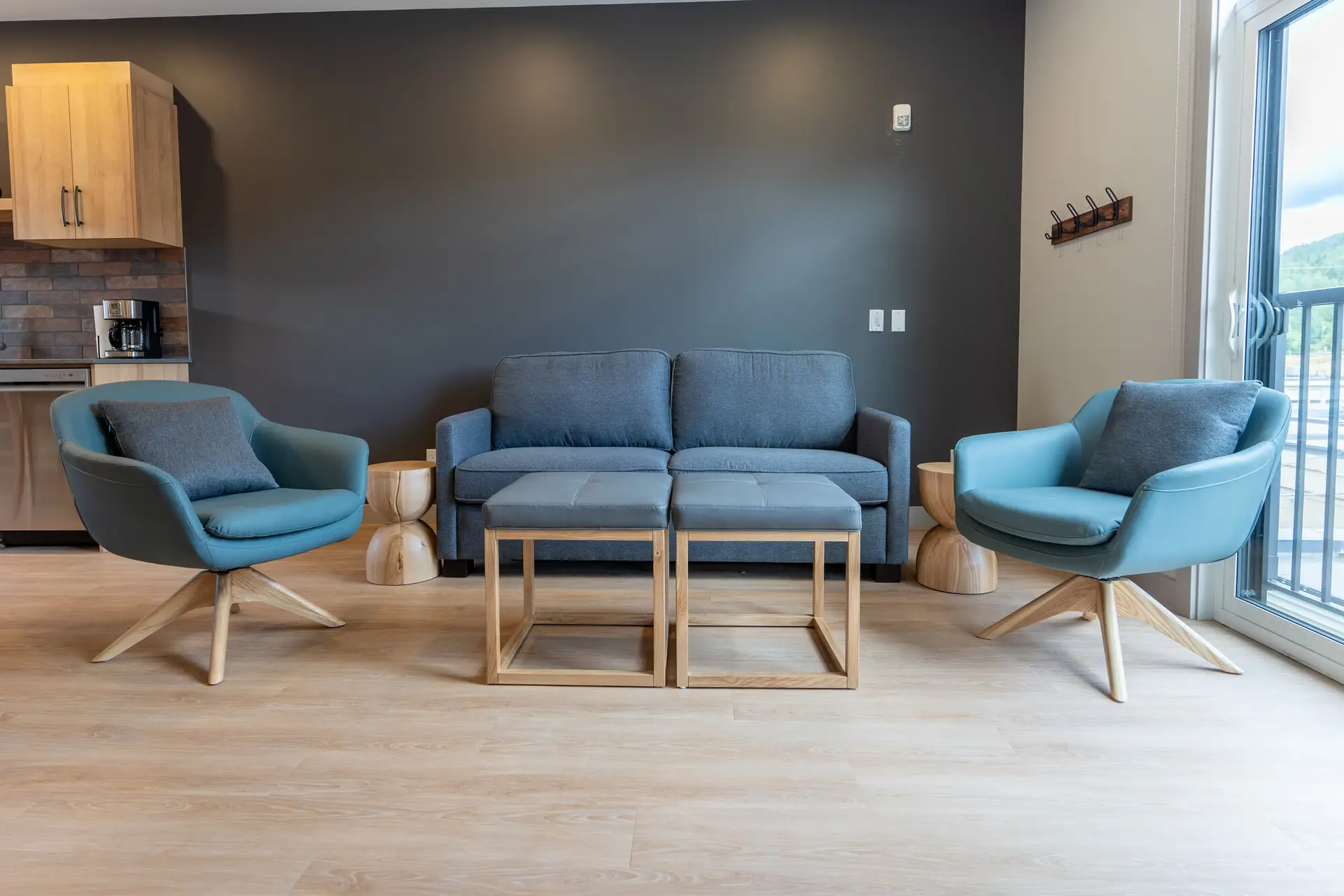 Basecamp Suites Revelstoke: Blue armchairs and sofa in a modern living room