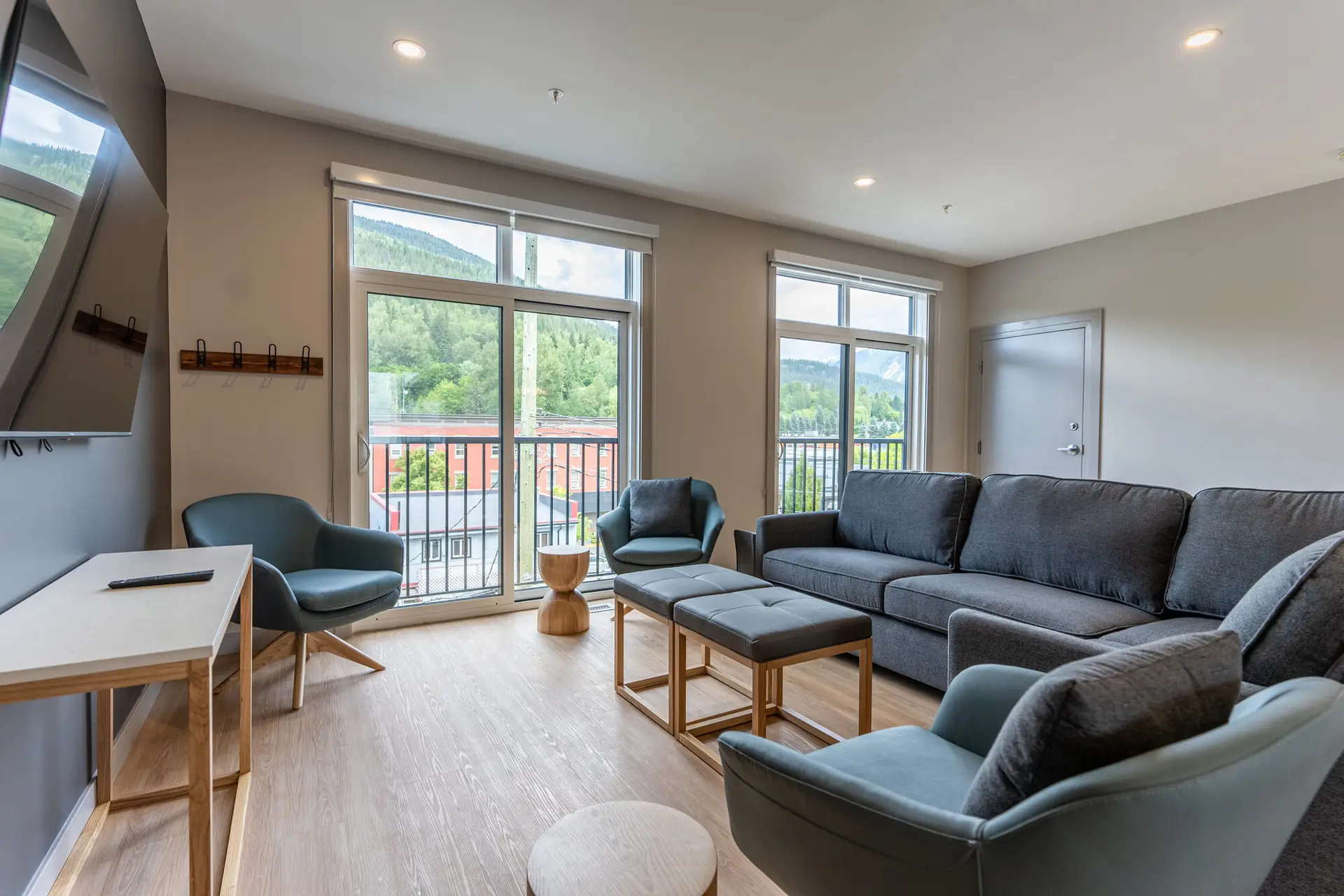 Living room of a Revelstoke six-bedroom suite with sectional sofa and mountain view