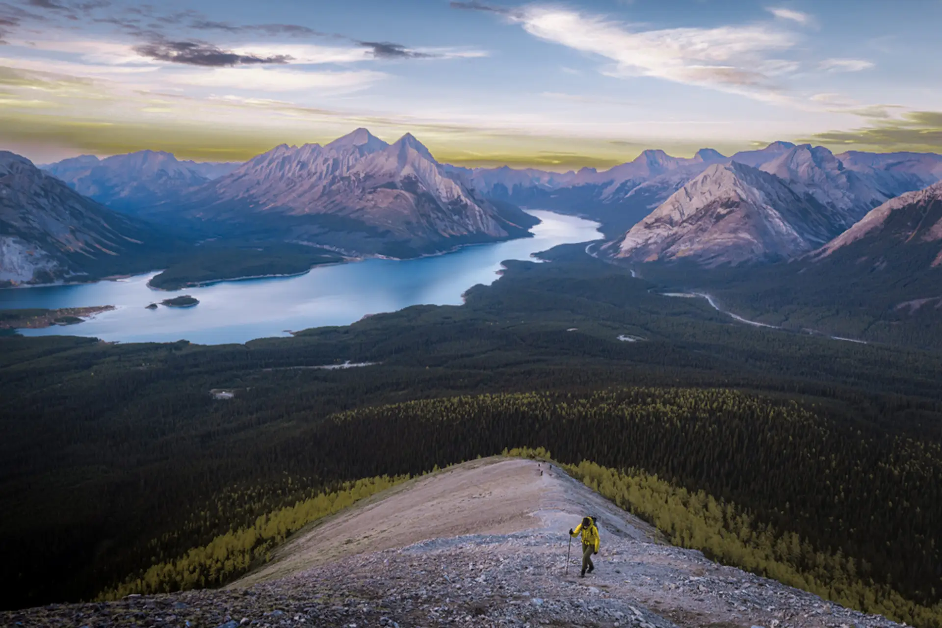 Hiker on a mountain ridge overlooking Kananaskis Lake and mountains, best Kananaskis hikes