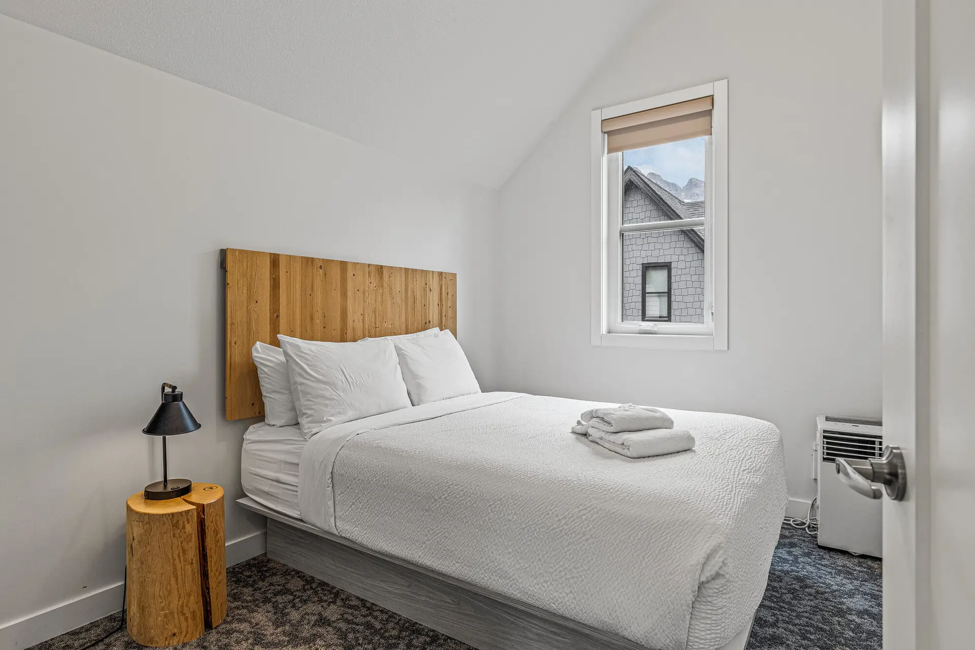 Cozy bedroom in Basecamp Resorts Canmore Three Bedroom Suite with a queen bed.