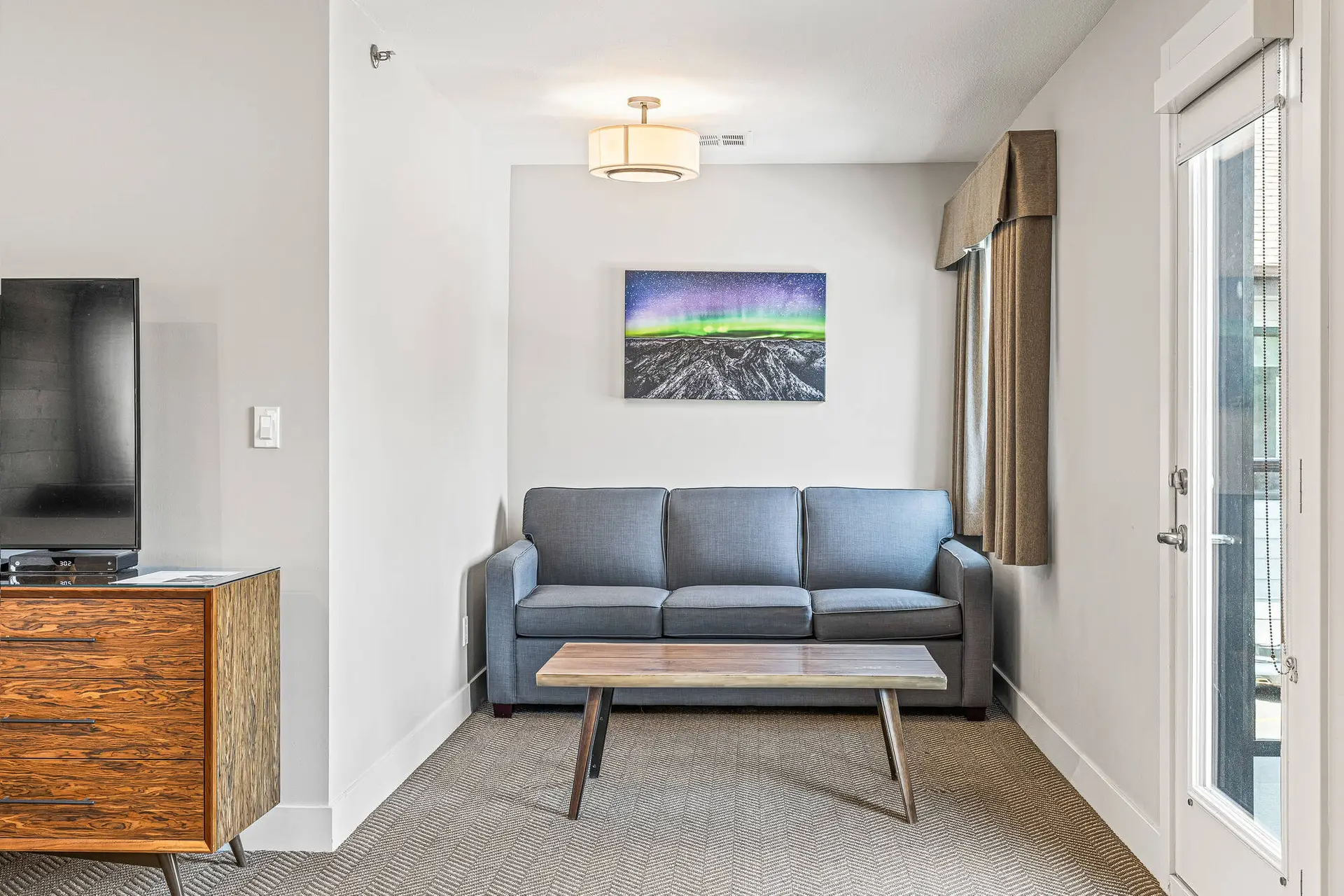 Basecamp Lodge Canmore King Suite living area with grey sofa and coffee table