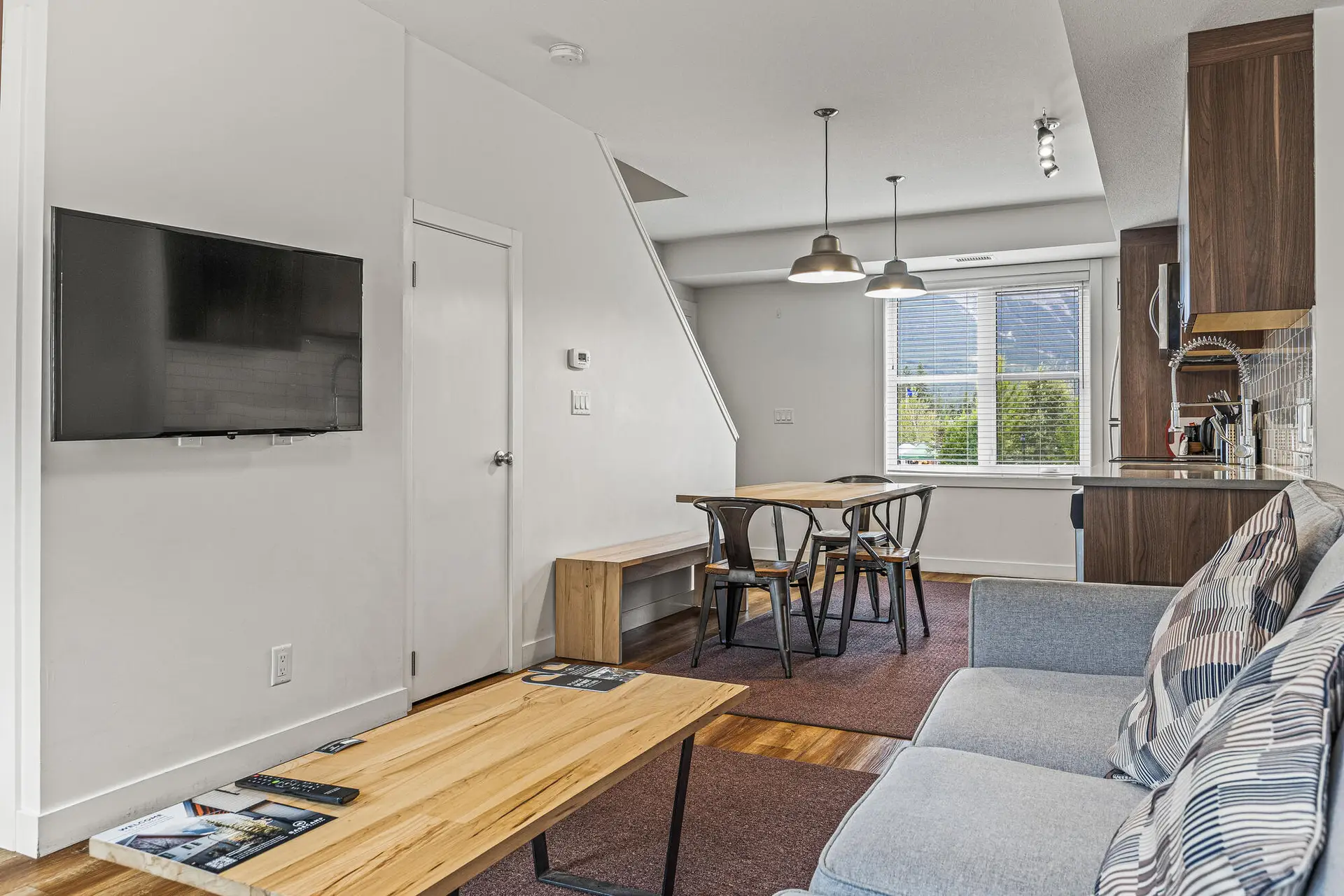 Basecamp Resorts Canmore two-bedroom suite living area with dining table and kitchen