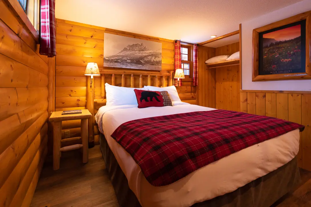 Cozy Baker Creek cabin bedroom with red plaid bedding and mountain art