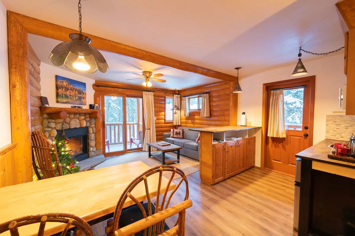 Basecamp Baker Creek suite living area with fireplace, dining table, and kitchen.
