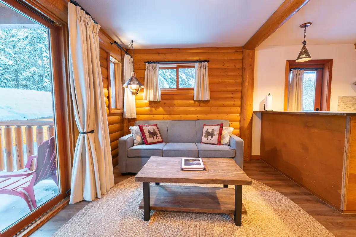 Cozy living area of a Baker Creek Superior Suite with wood-paneled walls, sofa, and coffee table.