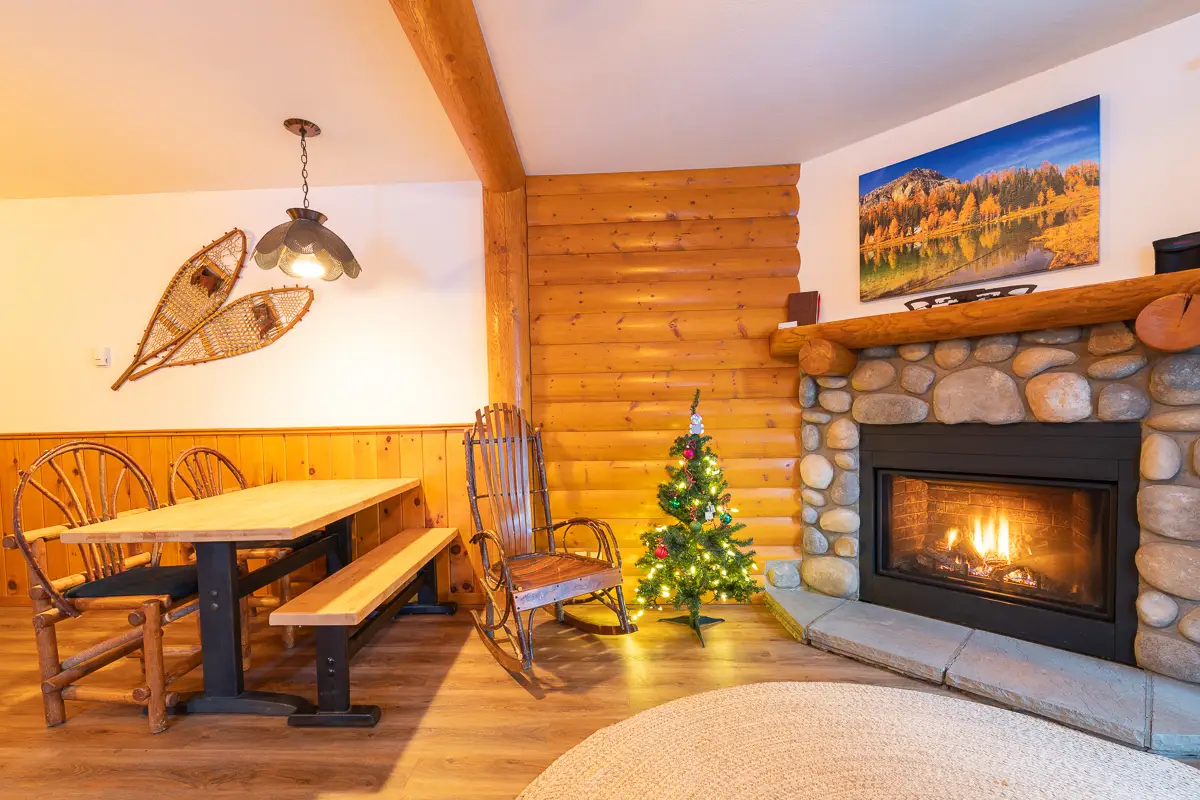 Cozy living area in Basecamp Baker Creek suite with fireplace & Christmas tree