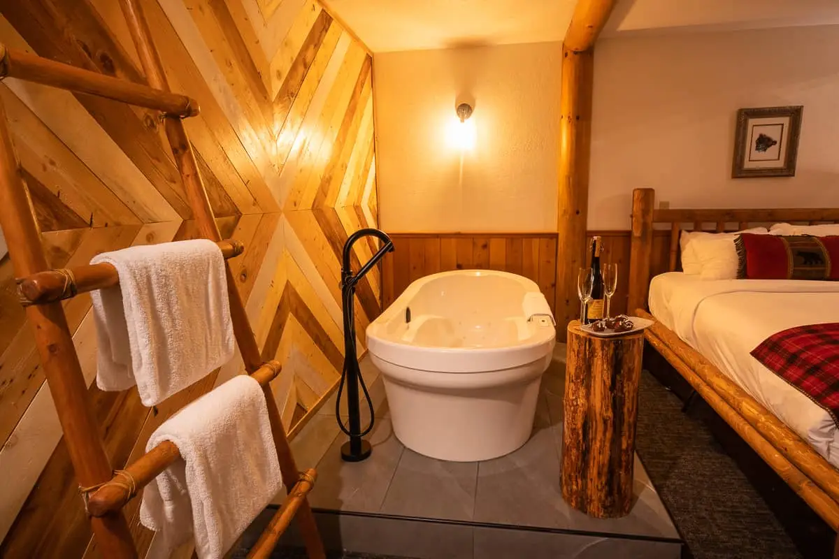 Basecamp Baker Creek Jacuzzi Suite: Tub, bed, and wooden accents