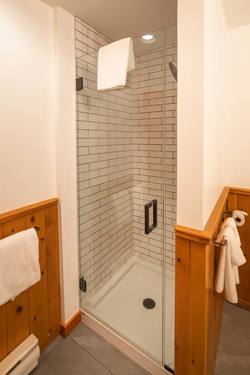 Modern tiled shower with glass door in a hotel bathroom
