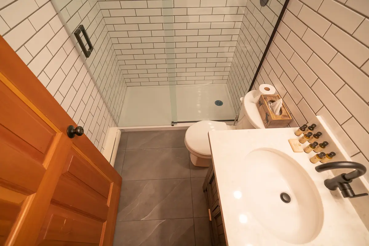 Basecamp Baker Creek: Modern bathroom with subway tile shower, vanity, and toilet.