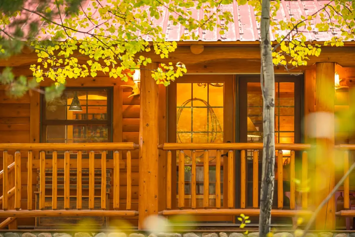Queen cabin at Basecamp Baker Creek with wooden porch and autumn foliage