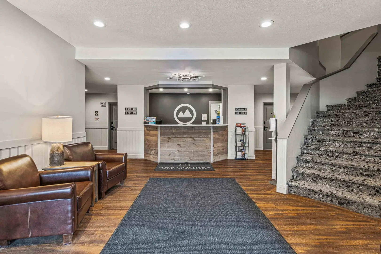 Northwinds Canmore hotel lobby with reception desk, seating, and stairs.