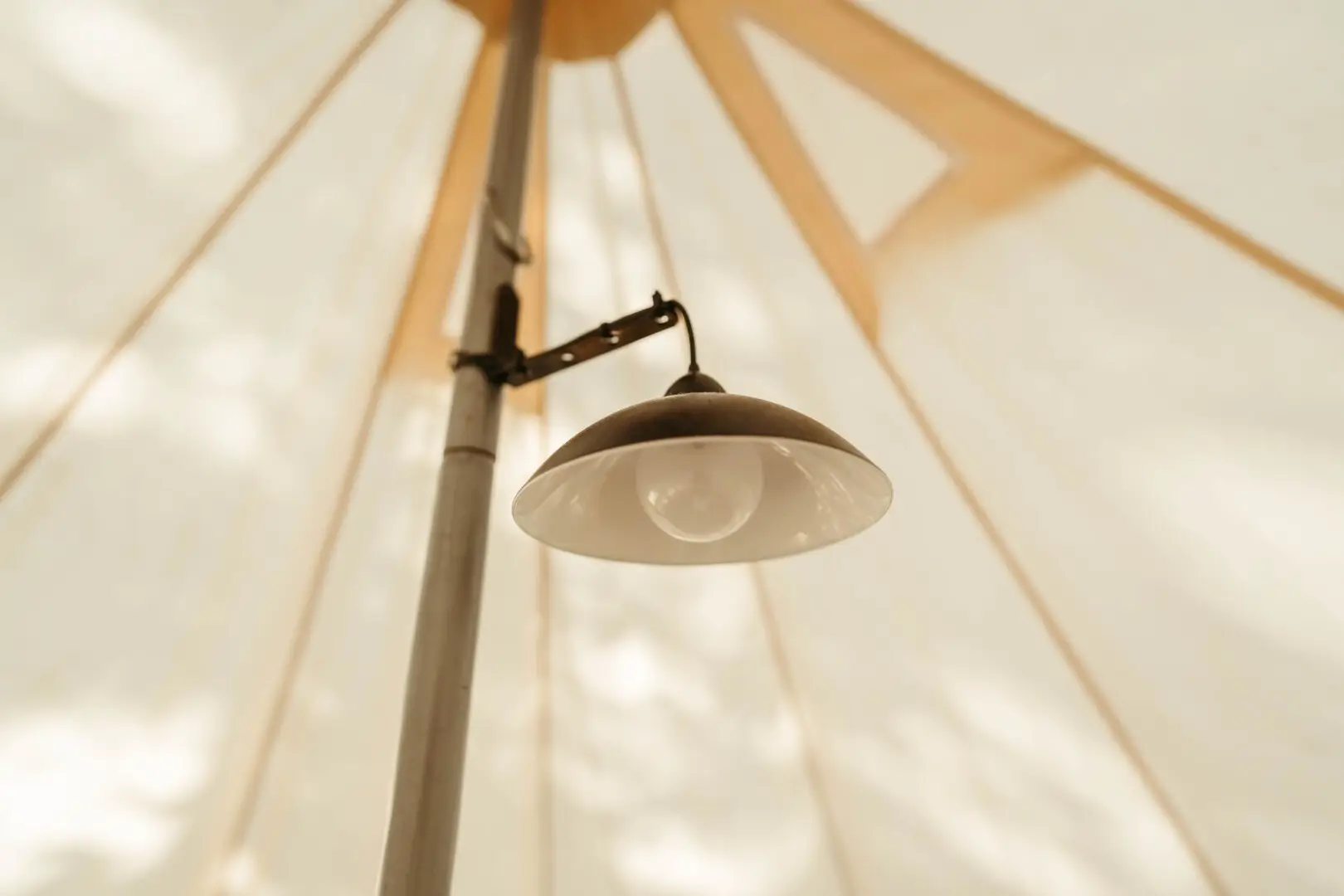 Interior view of a Basecamp Sundance canvas bell tent with a hanging light fixture.