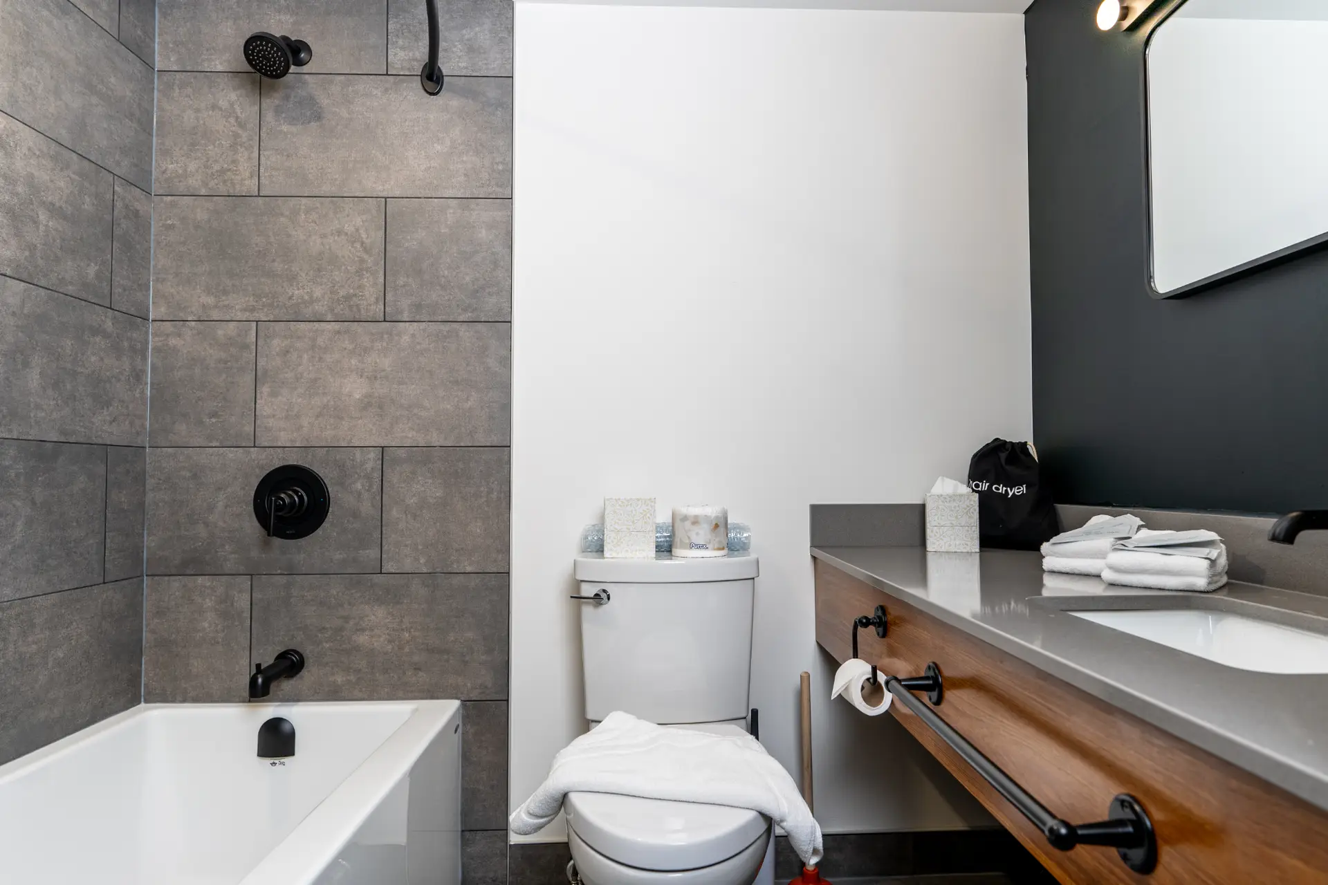 Modern bathroom with a walk-in shower, bathtub, and vanity at Basecamp Northwinds Revelstoke.