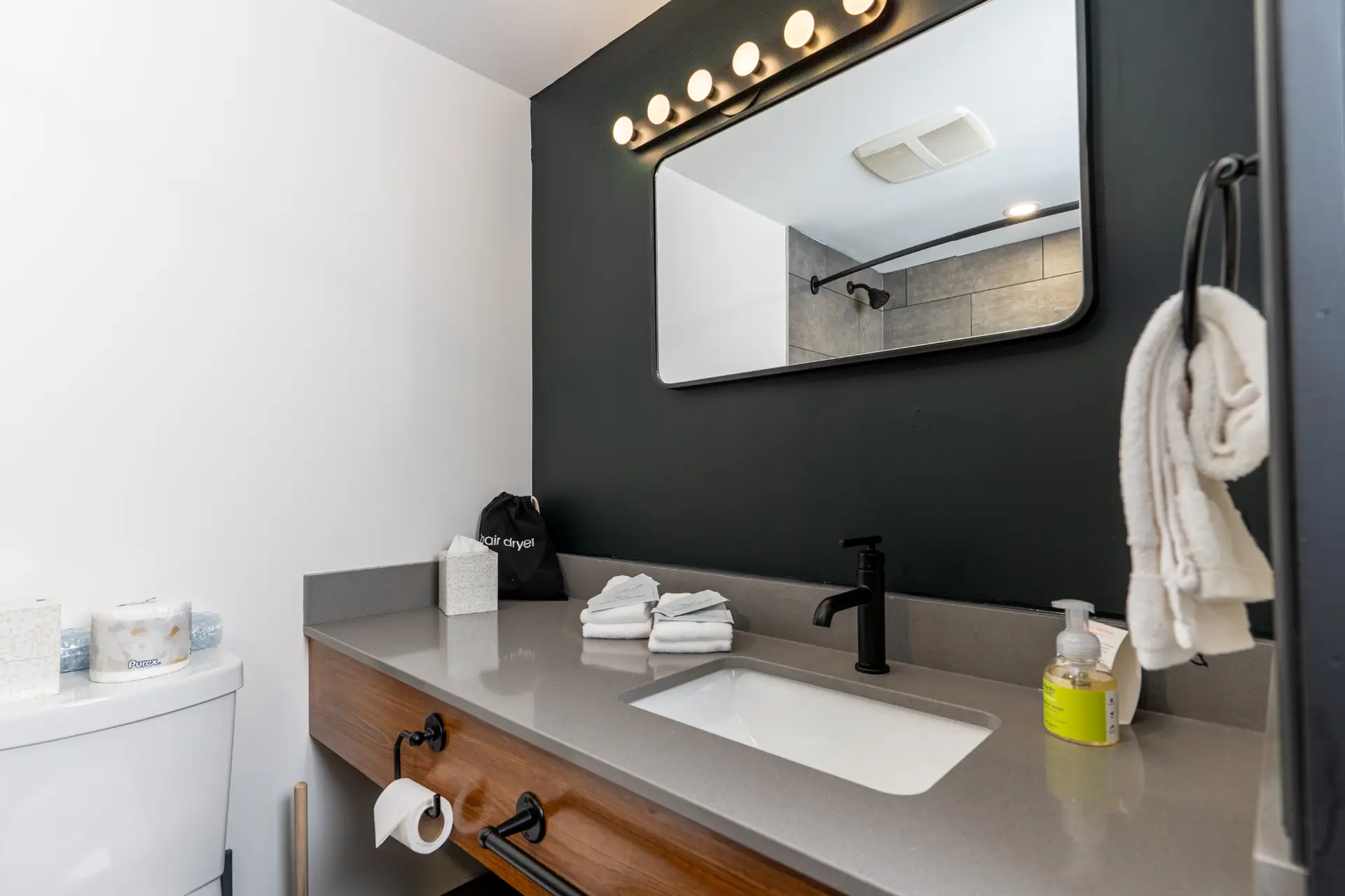 Revelstoke Double Queen bathroom vanity with sink, mirror, and toilet.