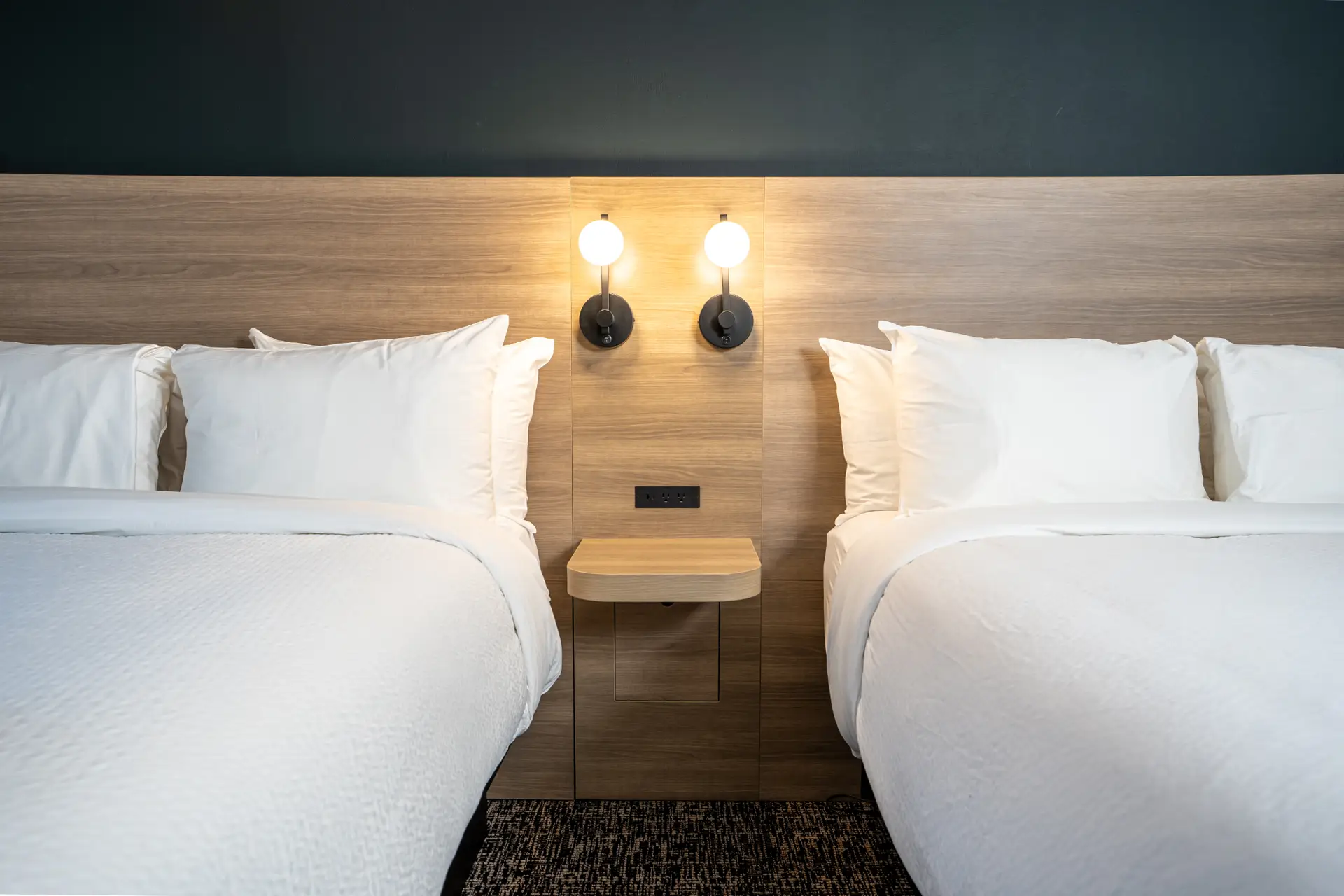 Double Queen suite at Basecamp Northwinds Revelstoke with two beds and modern lighting.
