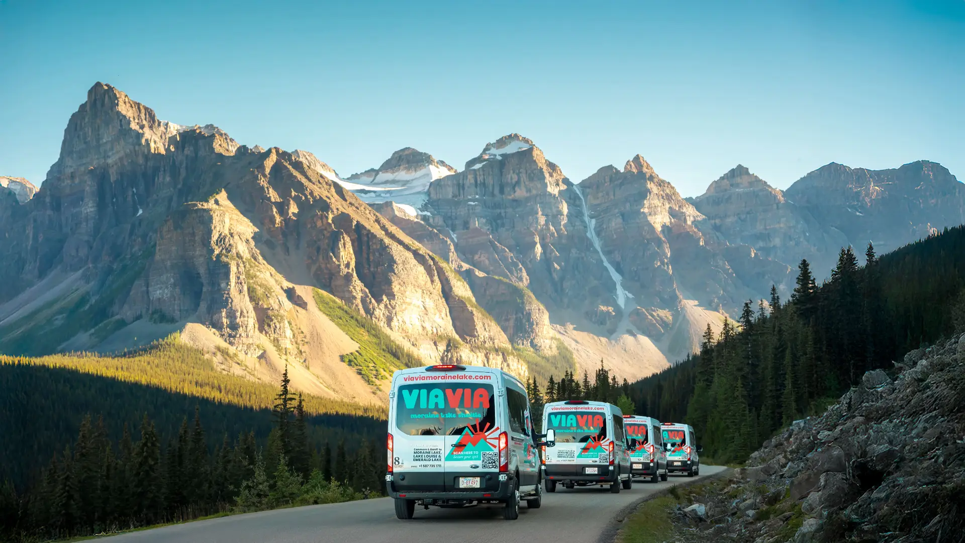 Via Via shuttles drive on a scenic mountain road in Banff National Park, Canada.