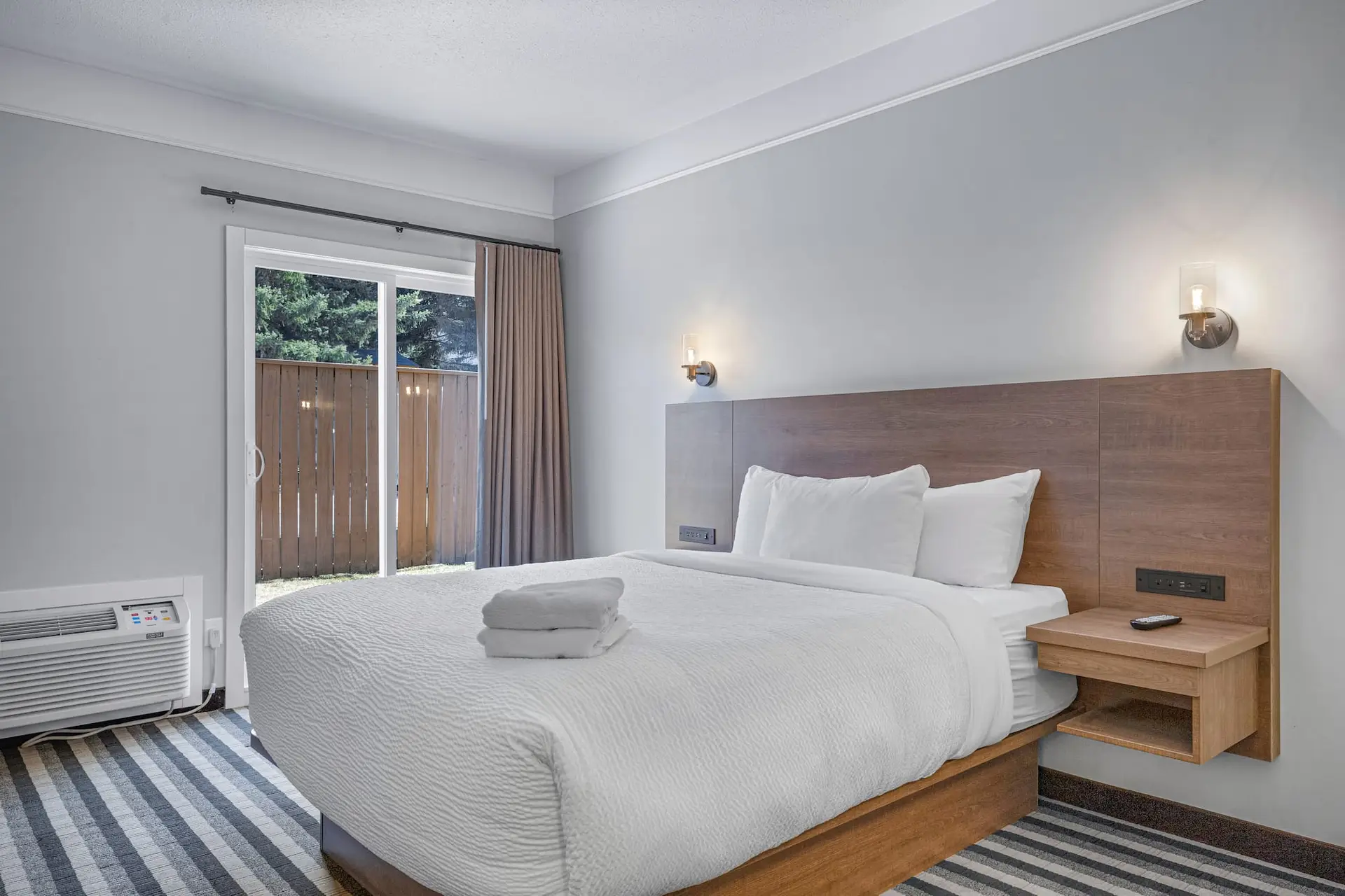 Deluxe Queen Room at Basecamp Northwinds Canmore with queen bed and patio access