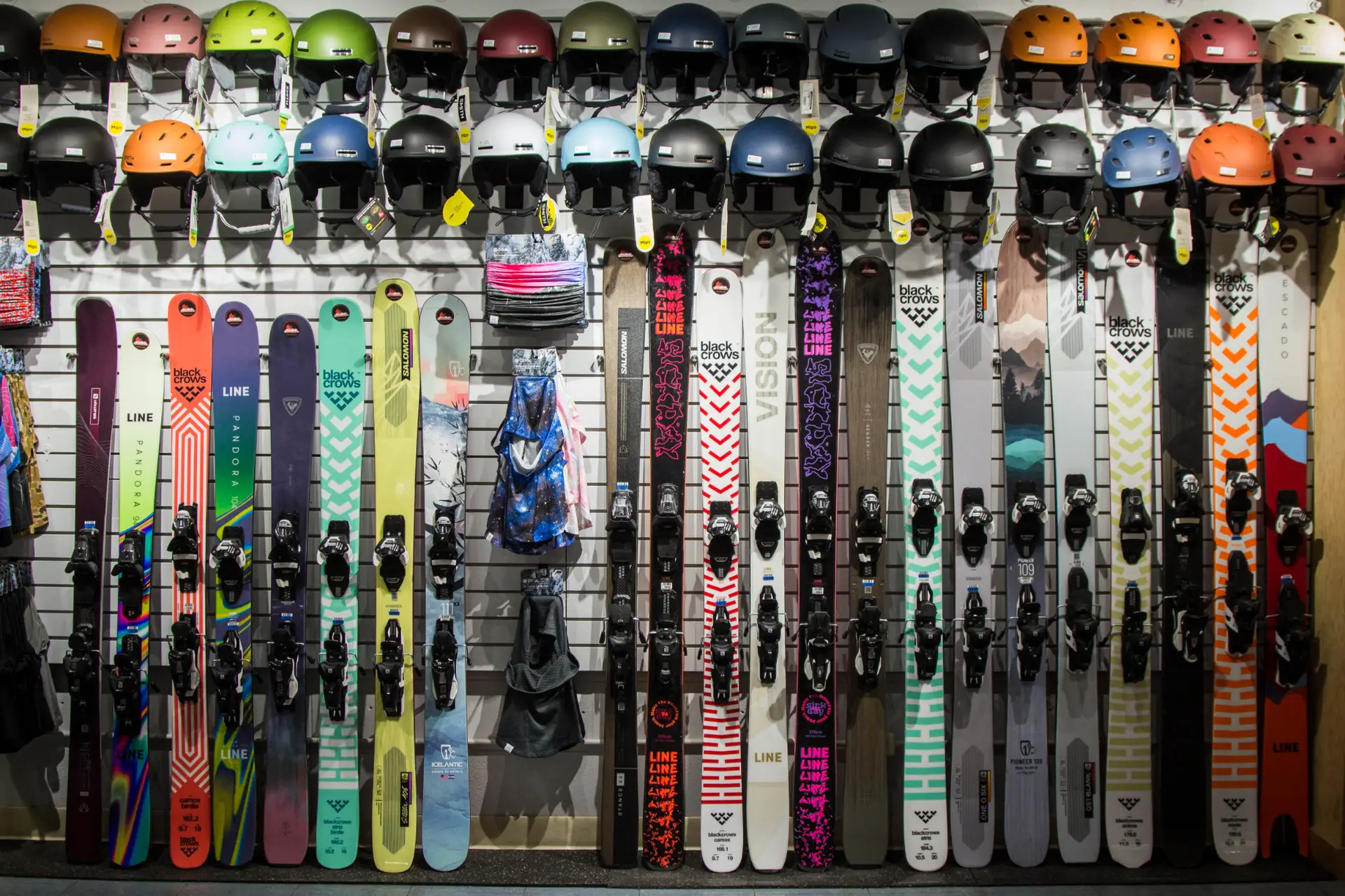 Colorful ski rentals, including skis and poles, displayed in a shop for powder rentals.