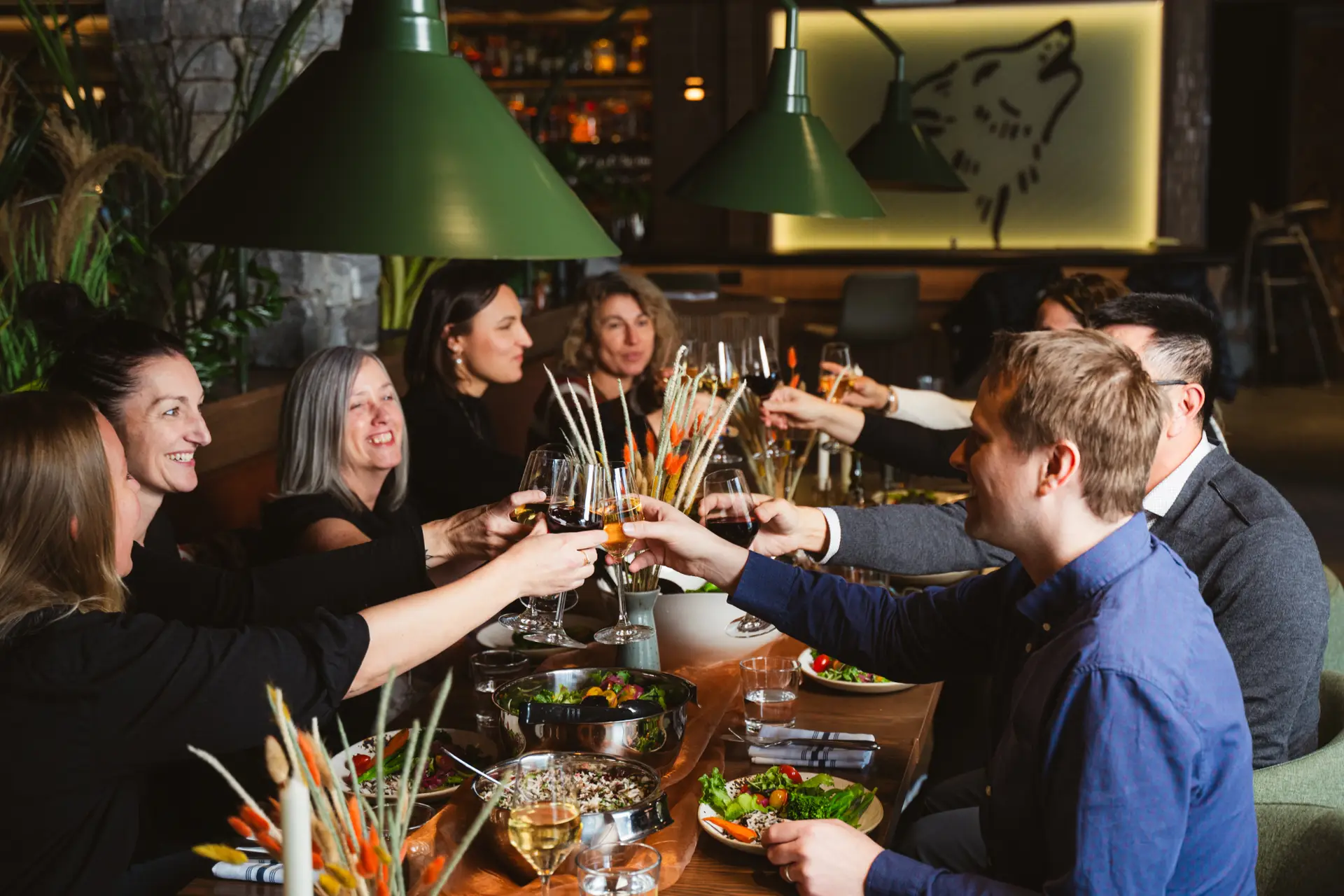 Group dining at Rhythm and Howl: friends toasting with wine at a restaurant table